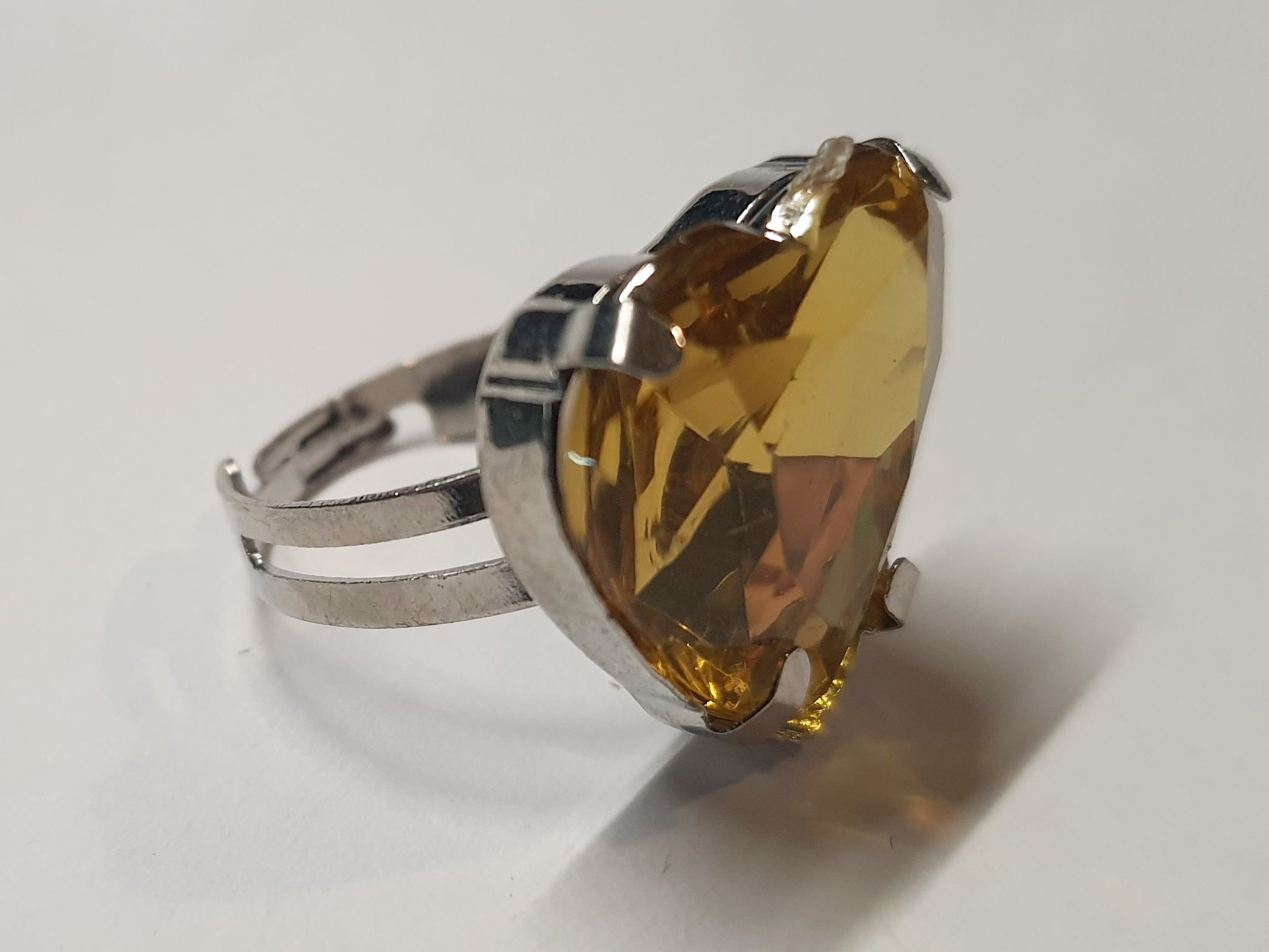 Srebrny pierścionek z dużym miodowo-złotym kamieniem w kształcie serca, metal, szlifowany kamień o ciepłym blasku, styl romantyczny glamour, regulowany rozmiar, Rouge Bizu.