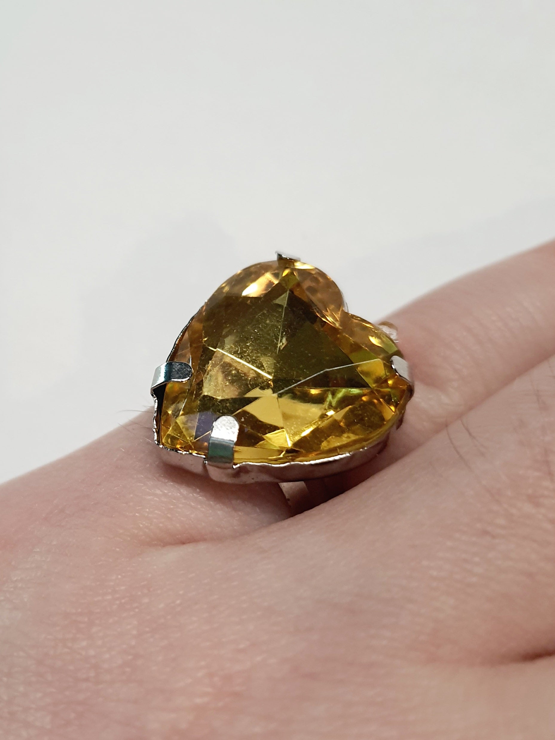 Srebrny pierścionek z dużym miodowo-złotym kamieniem w kształcie serca, metal, szlifowany kamień o ciepłym blasku, styl romantyczny glamour, regulowany rozmiar, Rouge Bizu.