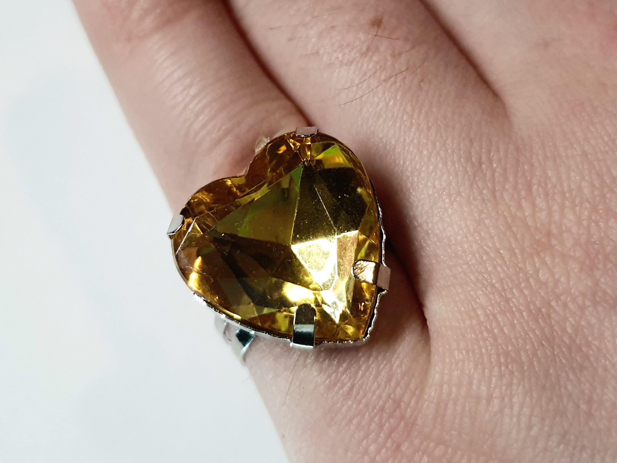 Srebrny pierścionek z dużym miodowo-złotym kamieniem w kształcie serca, metal, szlifowany kamień o ciepłym blasku, styl romantyczny glamour, regulowany rozmiar, Rouge Bizu.