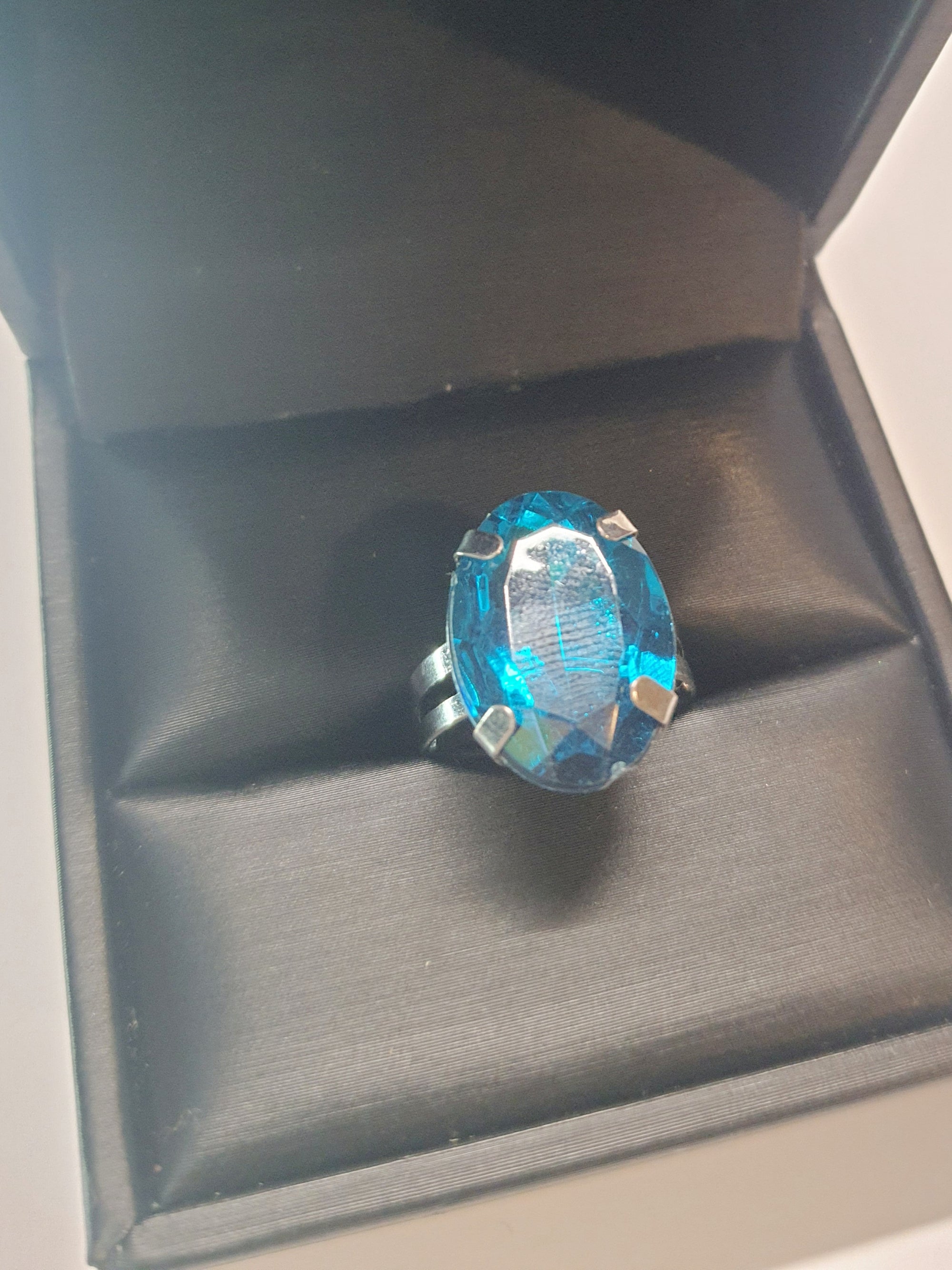 Srebrny pierścionek z dużym granatowo-niebieskim owalnym kamieniem, metal, szlifowany kamień o głębokim blasku, elegancki styl, regulowany rozmiar, Rouge Bizu.