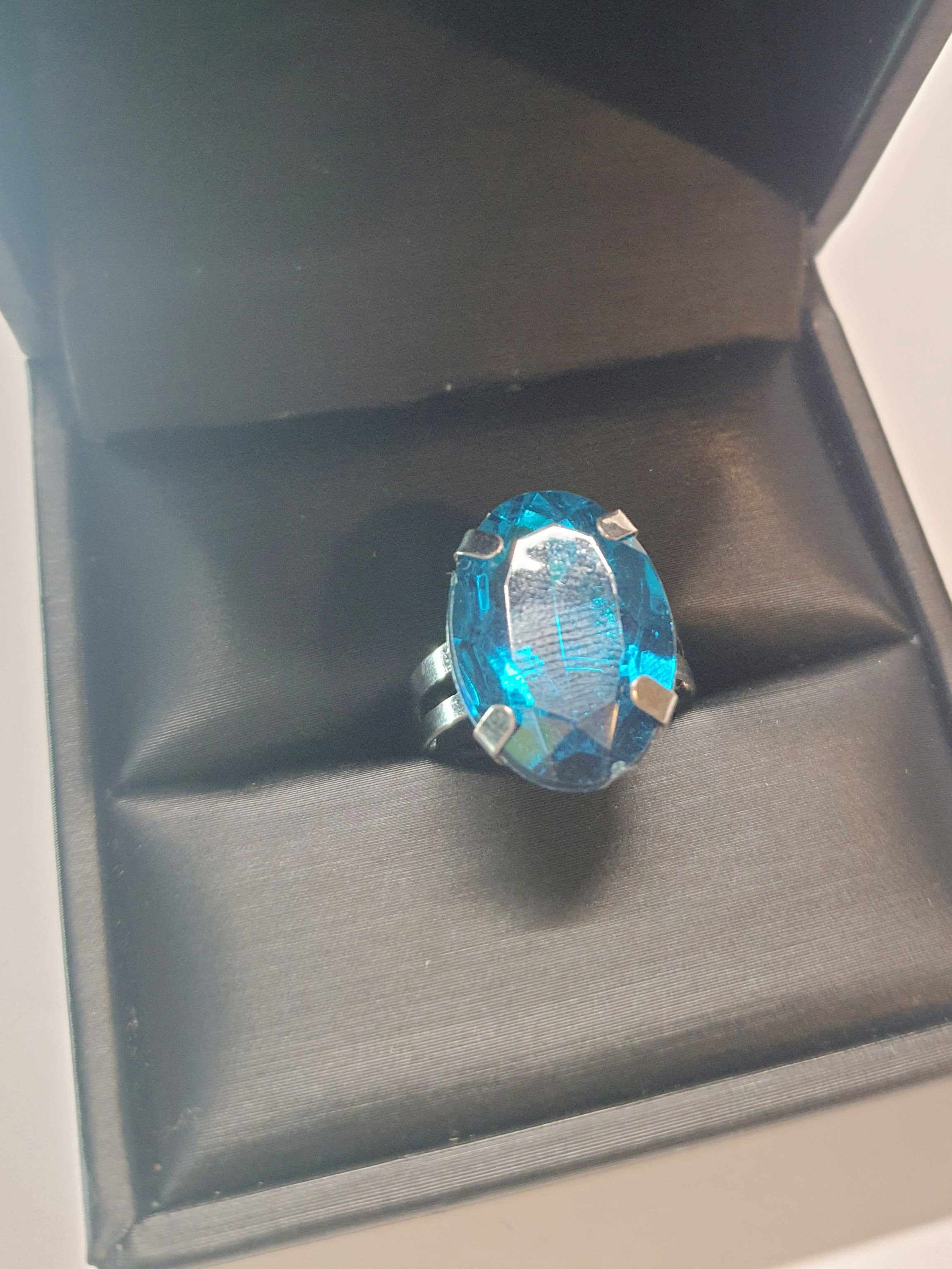 Srebrny pierścionek z dużym granatowo-niebieskim owalnym kamieniem, metal, szlifowany kamień o głębokim blasku, elegancki styl, regulowany rozmiar, Rouge Bizu.