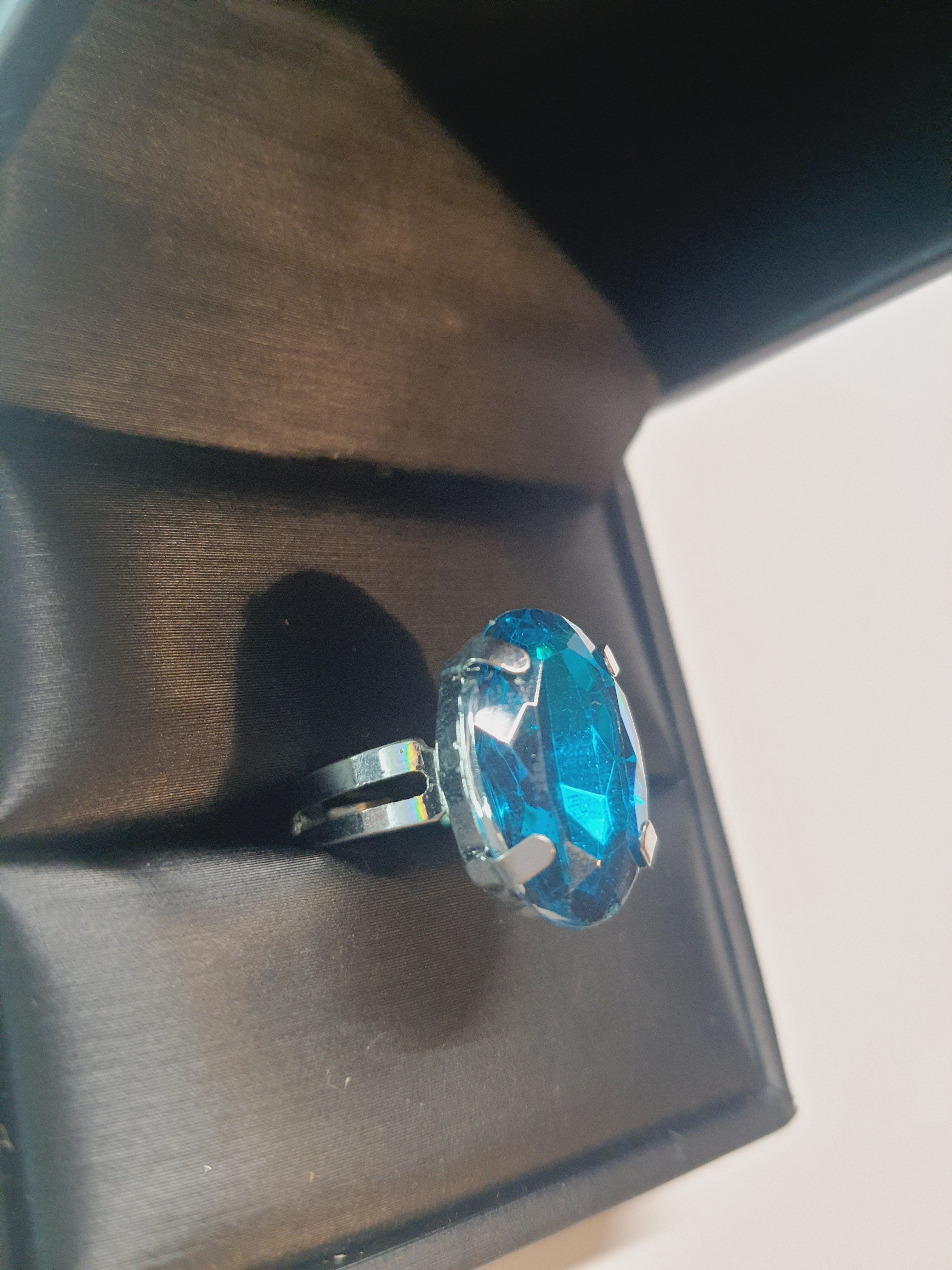 Srebrny pierścionek z dużym granatowo-niebieskim owalnym kamieniem, metal, szlifowany kamień o głębokim blasku, elegancki styl, regulowany rozmiar, Rouge Bizu.