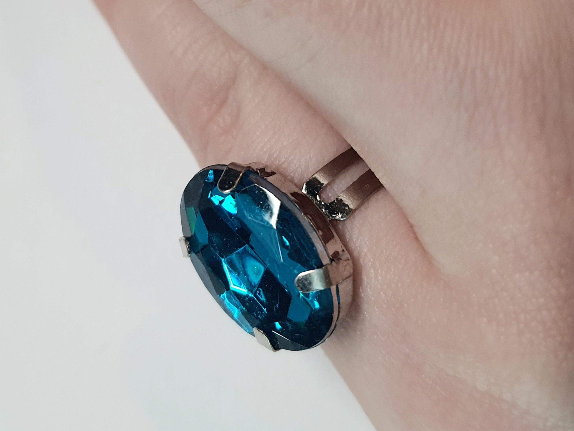 Srebrny pierścionek z dużym granatowo-niebieskim owalnym kamieniem, metal, szlifowany kamień o głębokim blasku, elegancki styl, regulowany rozmiar, Rouge Bizu.