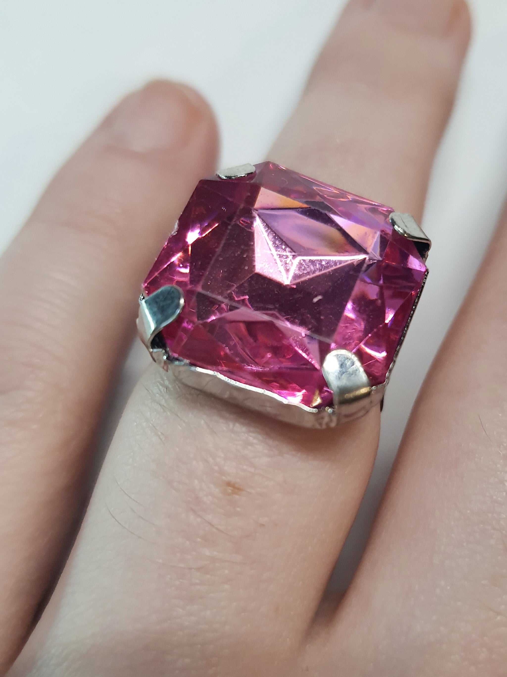 Srebrny pierścionek z dużym różowym kamieniem w kształcie kwadratu, metal, szlifowany kamień o intensywnym połysku, styl glamour, regulowany rozmiar, Rouge Bizu.