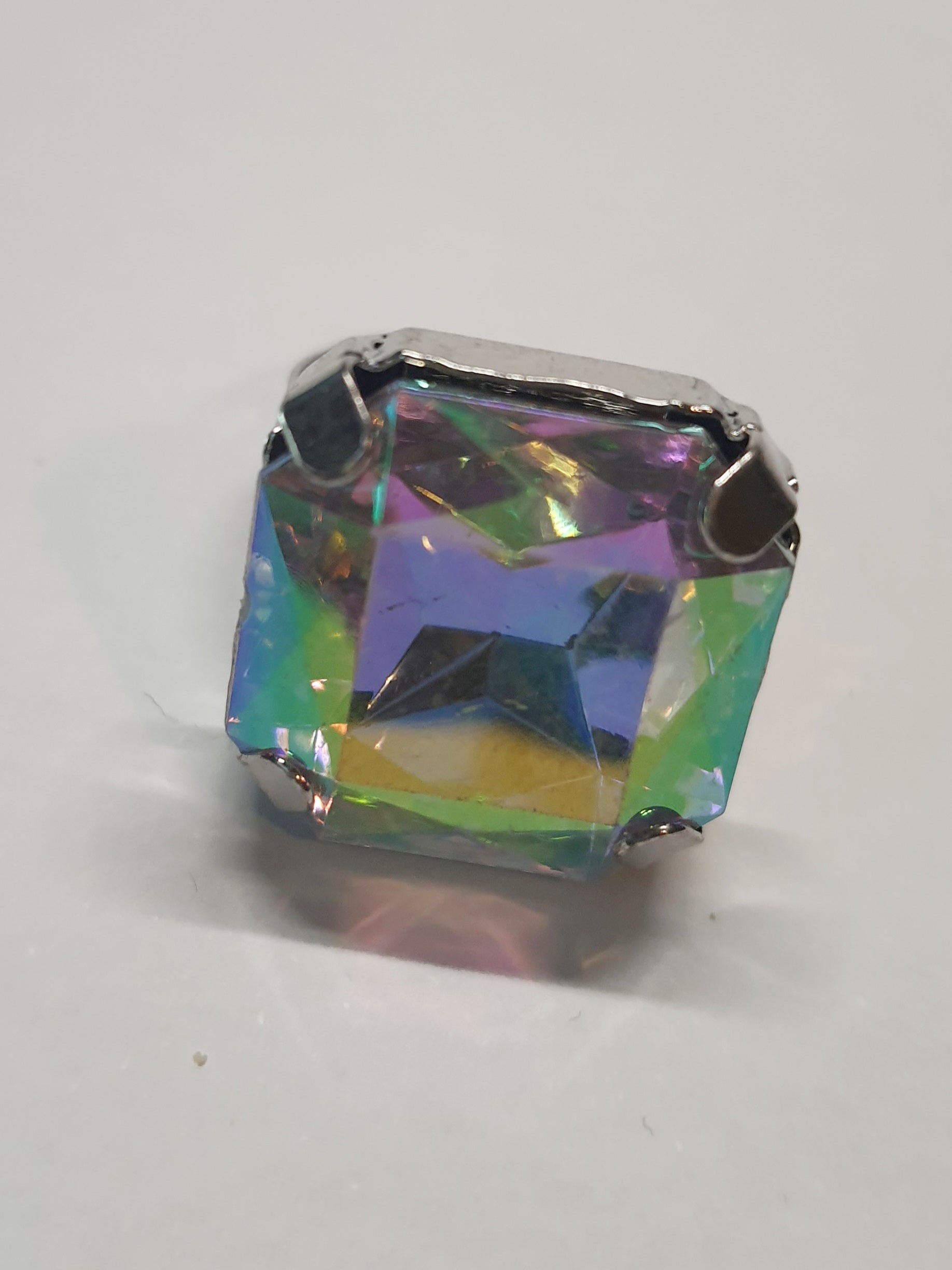Srebrny pierścionek z dużym wielokolorowym prostokątnym kamieniem, metal, szlifowany kamień o tęczowym połysku, styl glamour, regulowany rozmiar, Rouge Bizu.