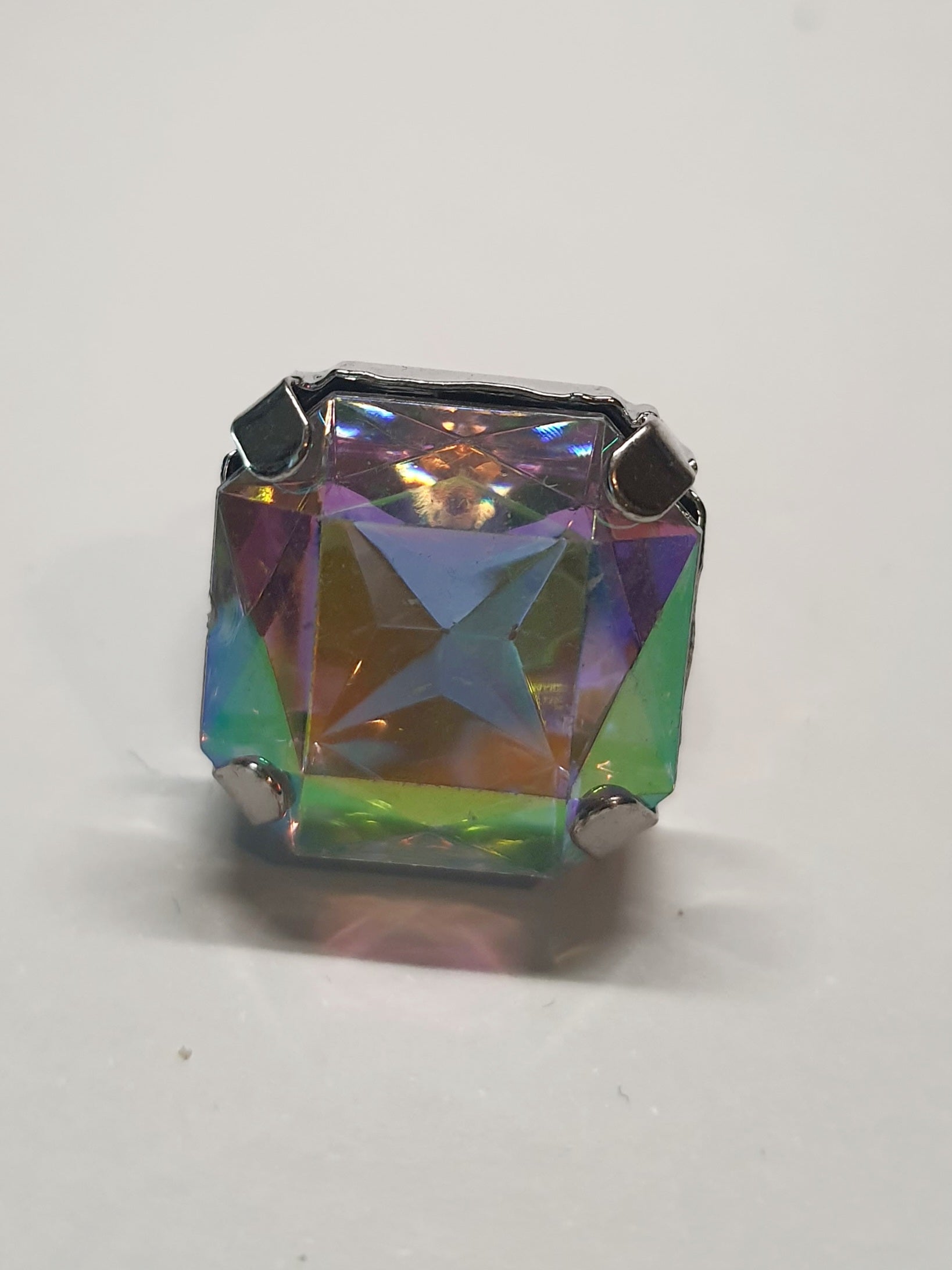 Srebrny pierścionek z dużym wielokolorowym prostokątnym kamieniem, metal, szlifowany kamień o tęczowym połysku, styl glamour, regulowany rozmiar, Rouge Bizu.