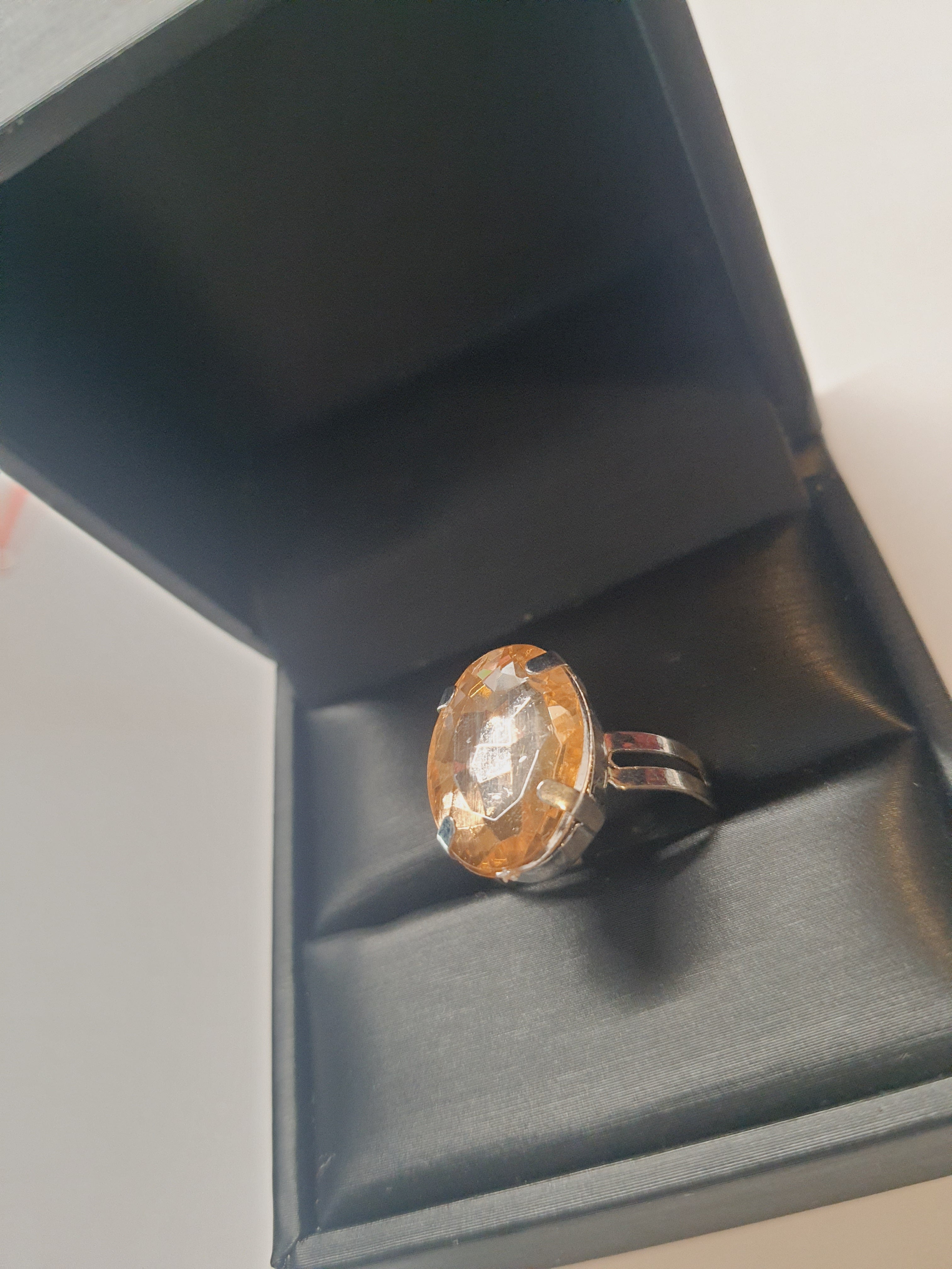 Srebrny pierścionek z dużym bursztynowo-złotym kamieniem o eleganckim szlifie. Regulowany rozmiar, klasyczny styl i ciepły blask. Rouge Bizu.