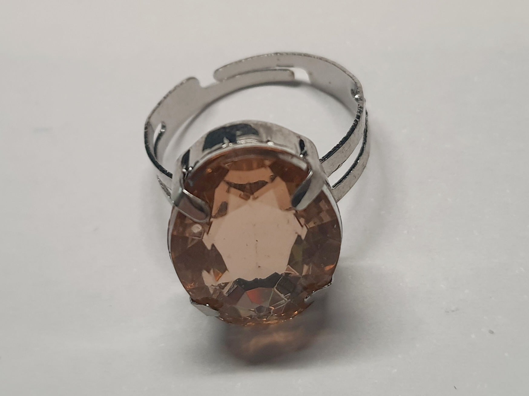 Srebrny pierścionek z dużym bursztynowo-złotym kamieniem o eleganckim szlifie. Regulowany rozmiar, klasyczny styl i ciepły blask. Rouge Bizu.