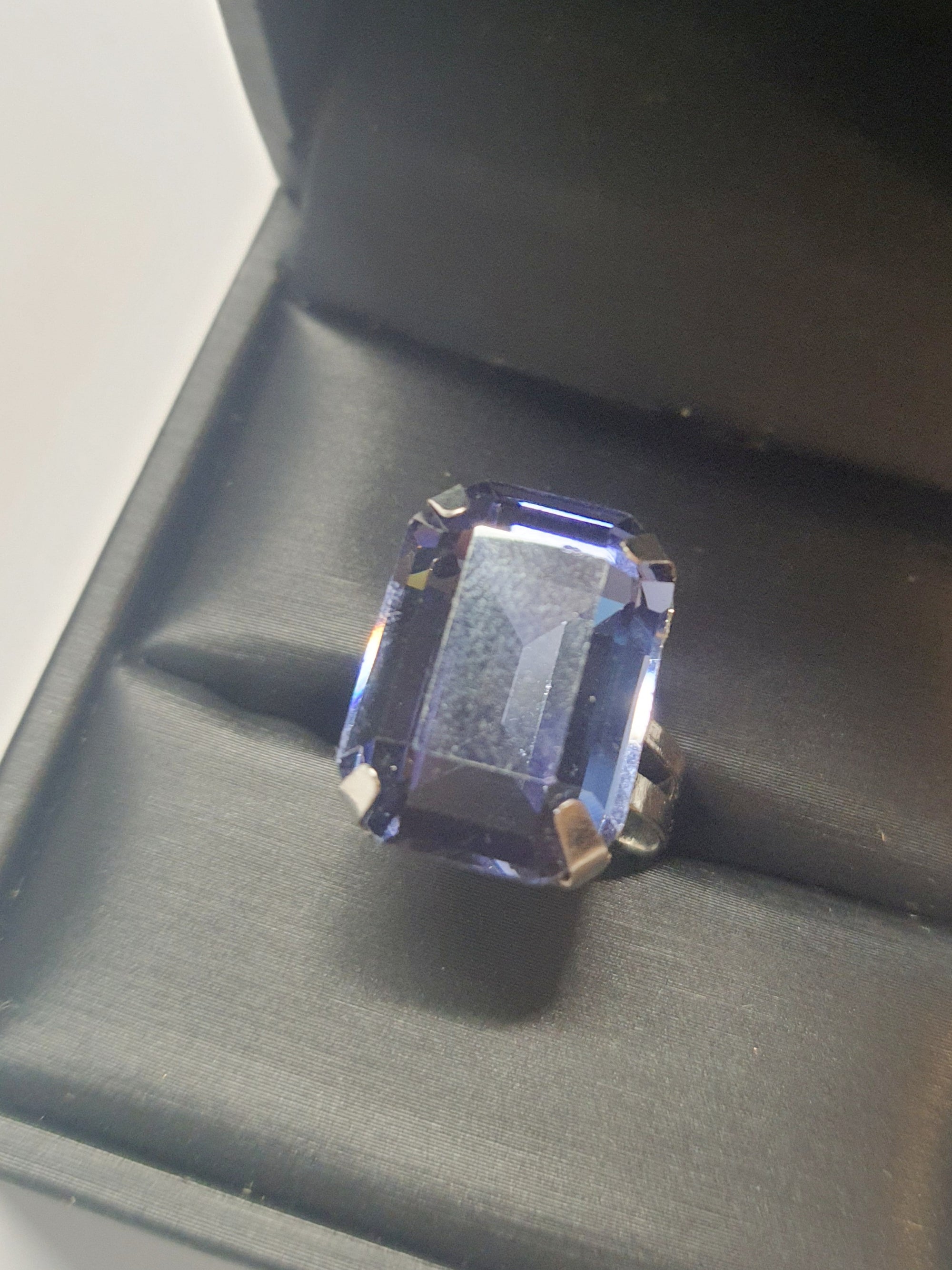 Srebrny pierścionek z prostokątnym fioletowym kamieniem w eleganckim szlifie, metal, chłodny odcień, klasyczny styl, regulowany rozmiar, Rouge Bizu.