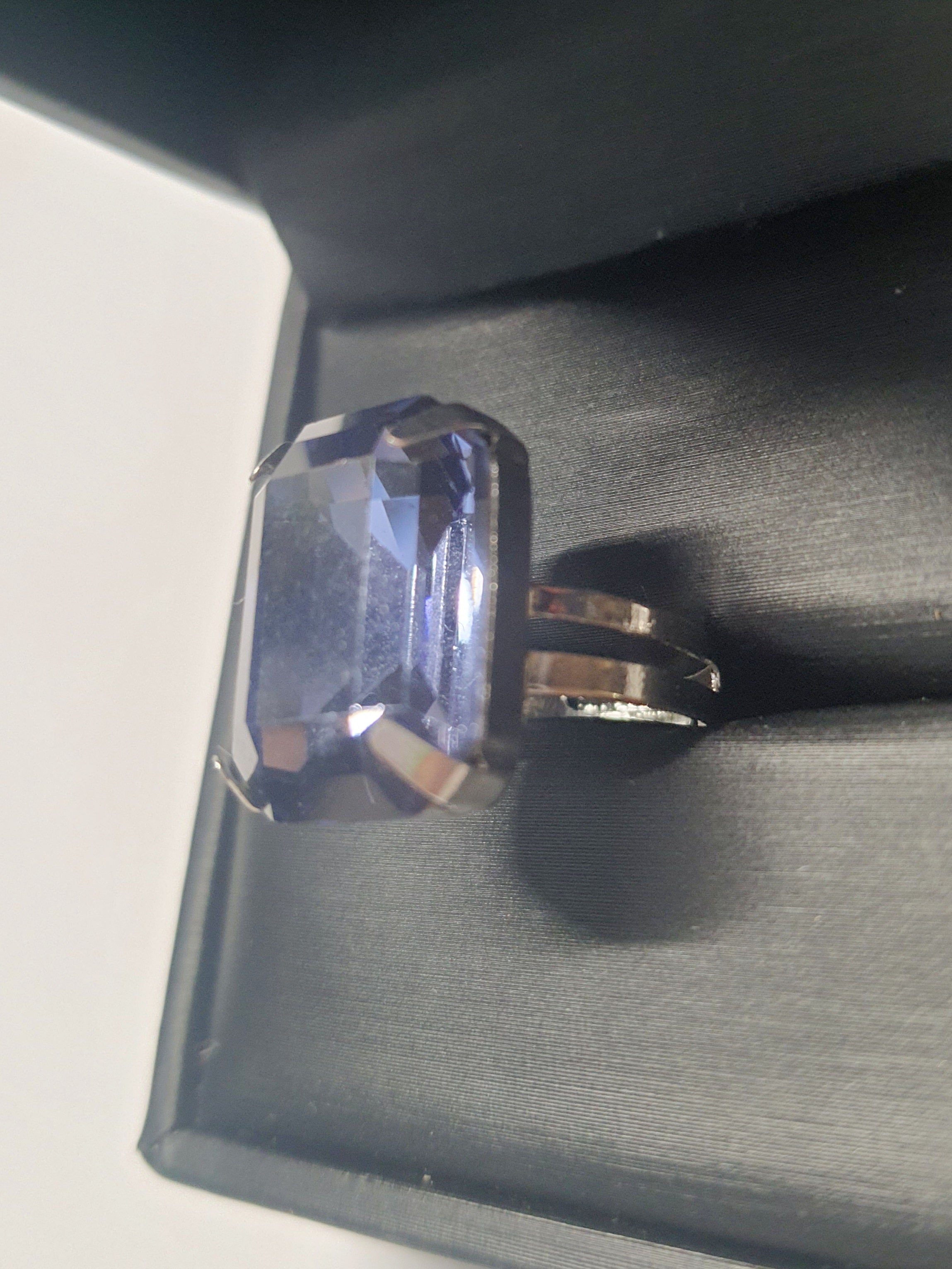 Srebrny pierścionek z prostokątnym fioletowym kamieniem w eleganckim szlifie, metal, chłodny odcień, klasyczny styl, regulowany rozmiar, Rouge Bizu.