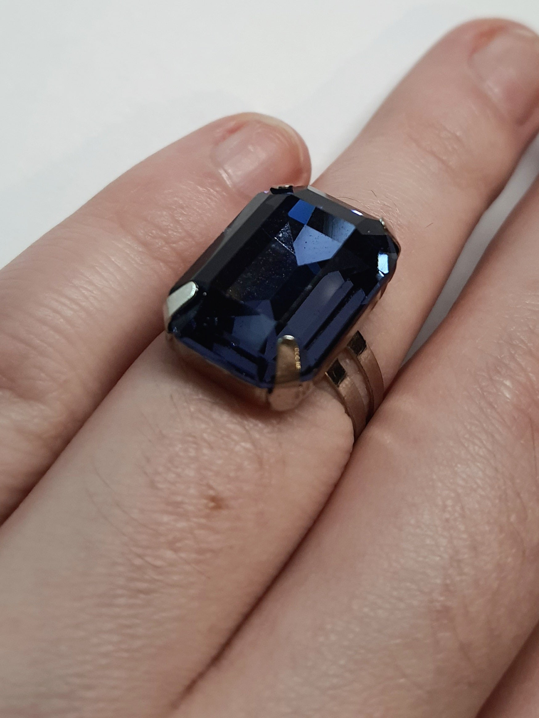 Srebrny pierścionek z prostokątnym fioletowym kamieniem w eleganckim szlifie, metal, chłodny odcień, klasyczny styl, regulowany rozmiar, Rouge Bizu.