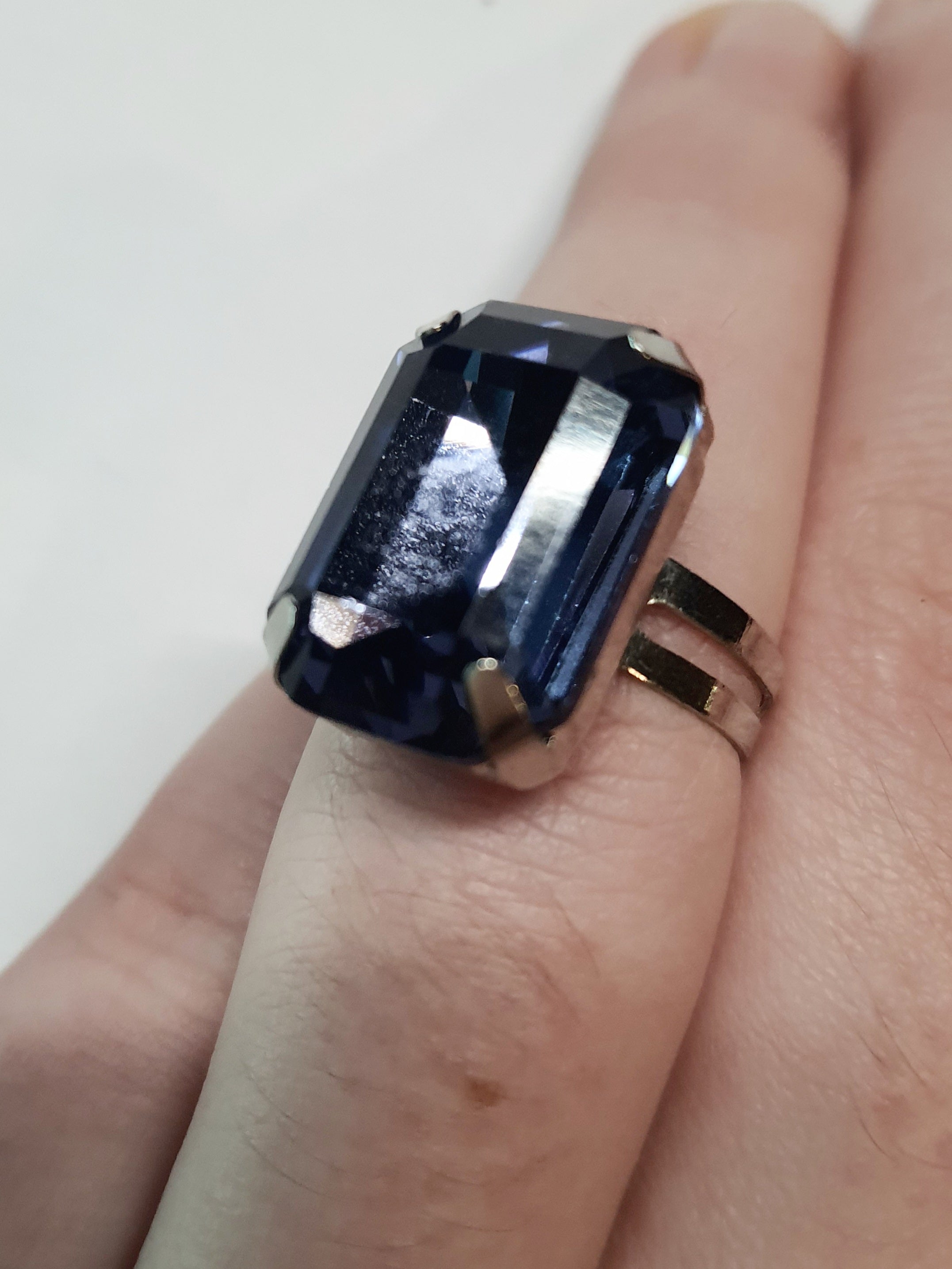 Srebrny pierścionek z prostokątnym fioletowym kamieniem w eleganckim szlifie, metal, chłodny odcień, klasyczny styl, regulowany rozmiar, Rouge Bizu.