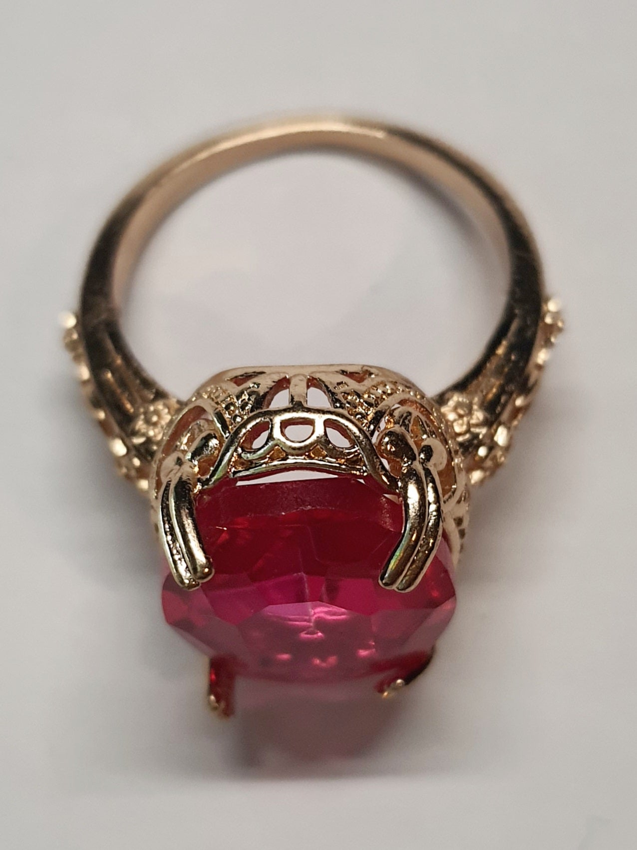 Złoty pierścionek z dużym rubinowym kamieniem w stylu vintage, bogato zdobiony, elegancki i kobiecy. Rozmiar 20 mm. Stal nierdzewna, stal chirurgiczna, wodoodporne, hipoalergiczne, jakość premium. Rouge Bizu.