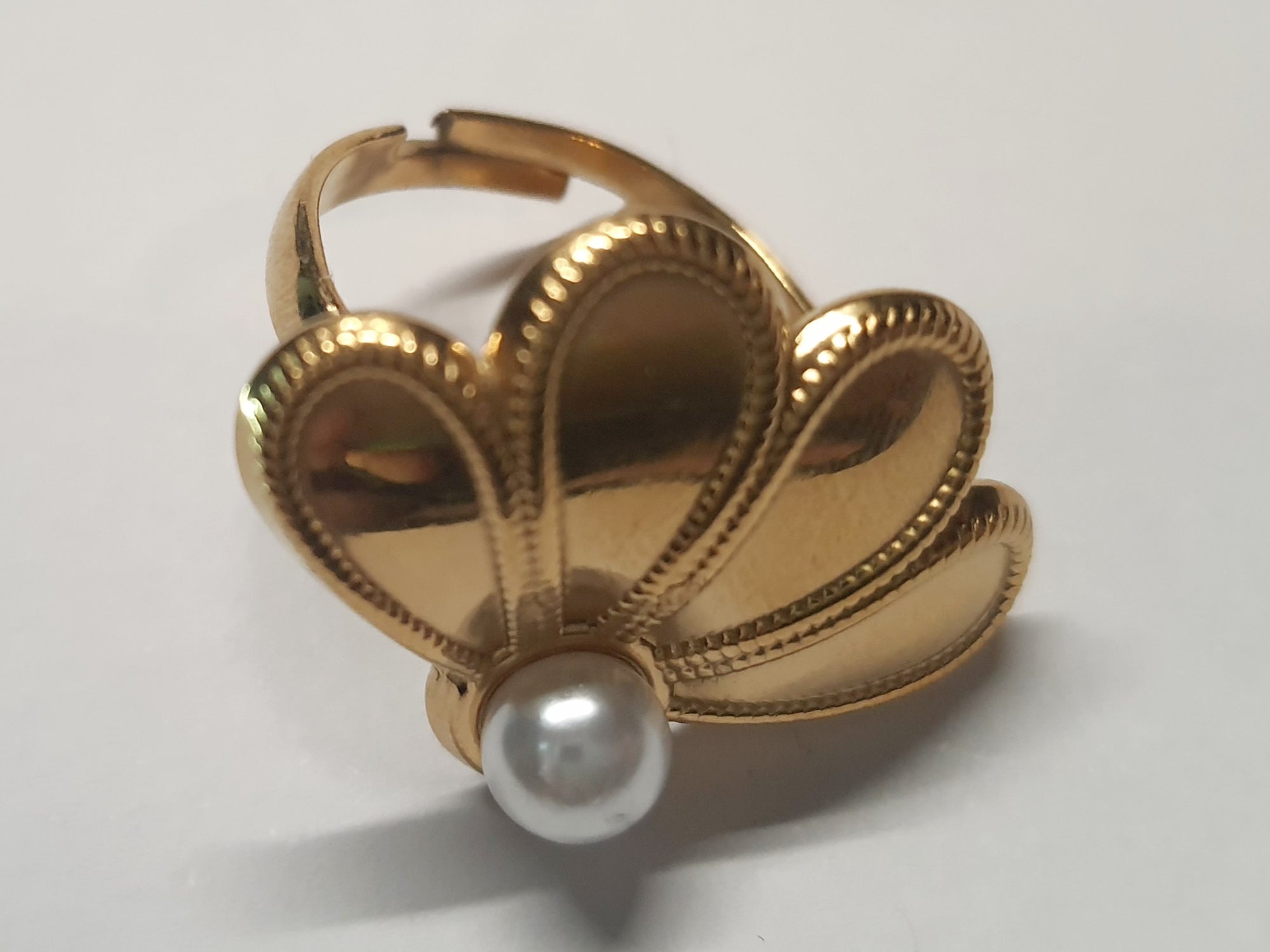 Złoty pierścionek w kształcie wachlarza z białą perłą, elegancki i nowoczesny. Rozmiar 17 mm, lekko regulowany. Stal nierdzewna, stal chirurgiczna, wodoodporne, hipoalergiczne, jakość premium. Rouge Bizu.