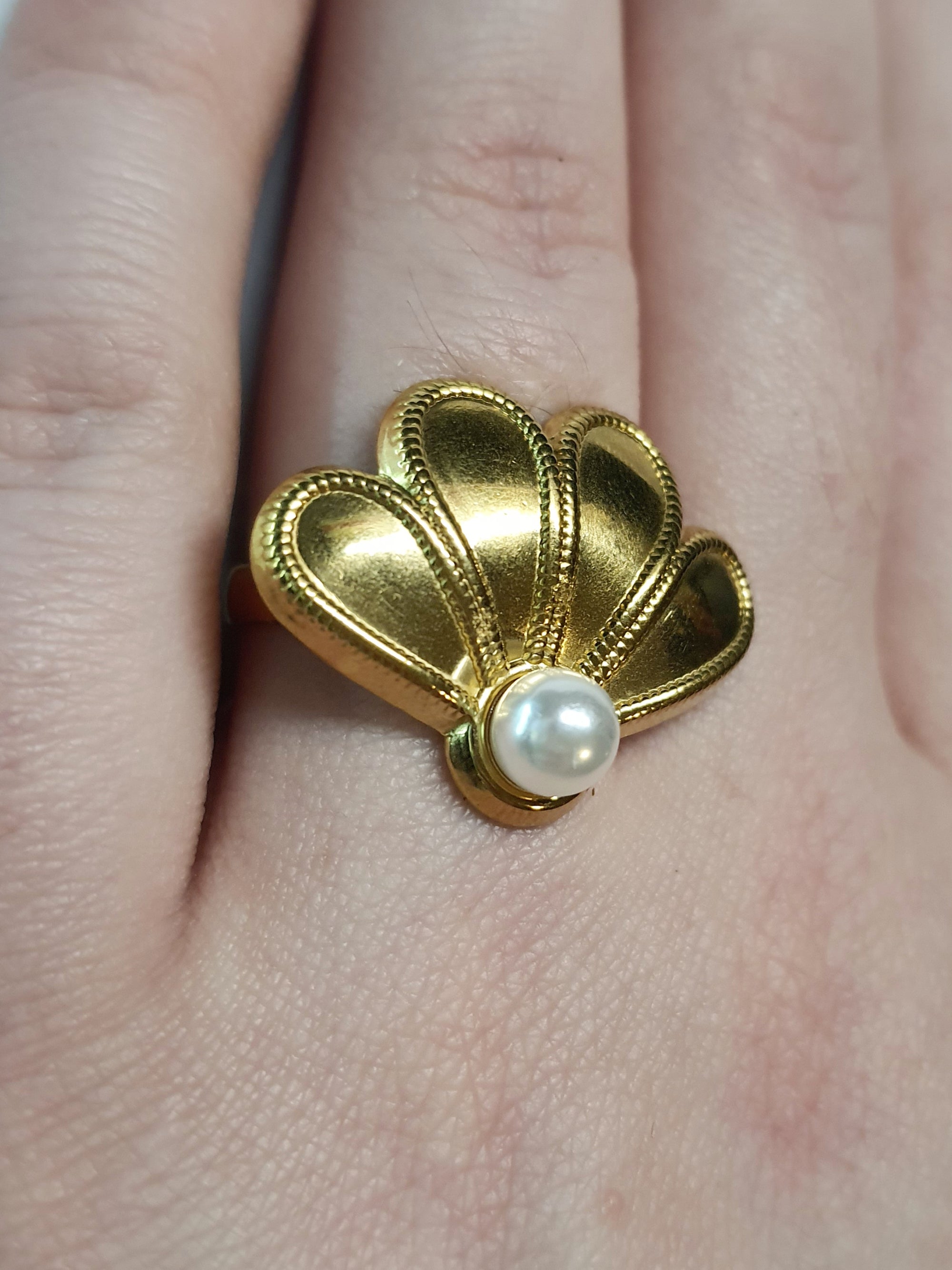 Złoty pierścionek w kształcie wachlarza z białą perłą, elegancki i nowoczesny. Rozmiar 17 mm, lekko regulowany. Stal nierdzewna, stal chirurgiczna, wodoodporne, hipoalergiczne, jakość premium. Rouge Bizu.