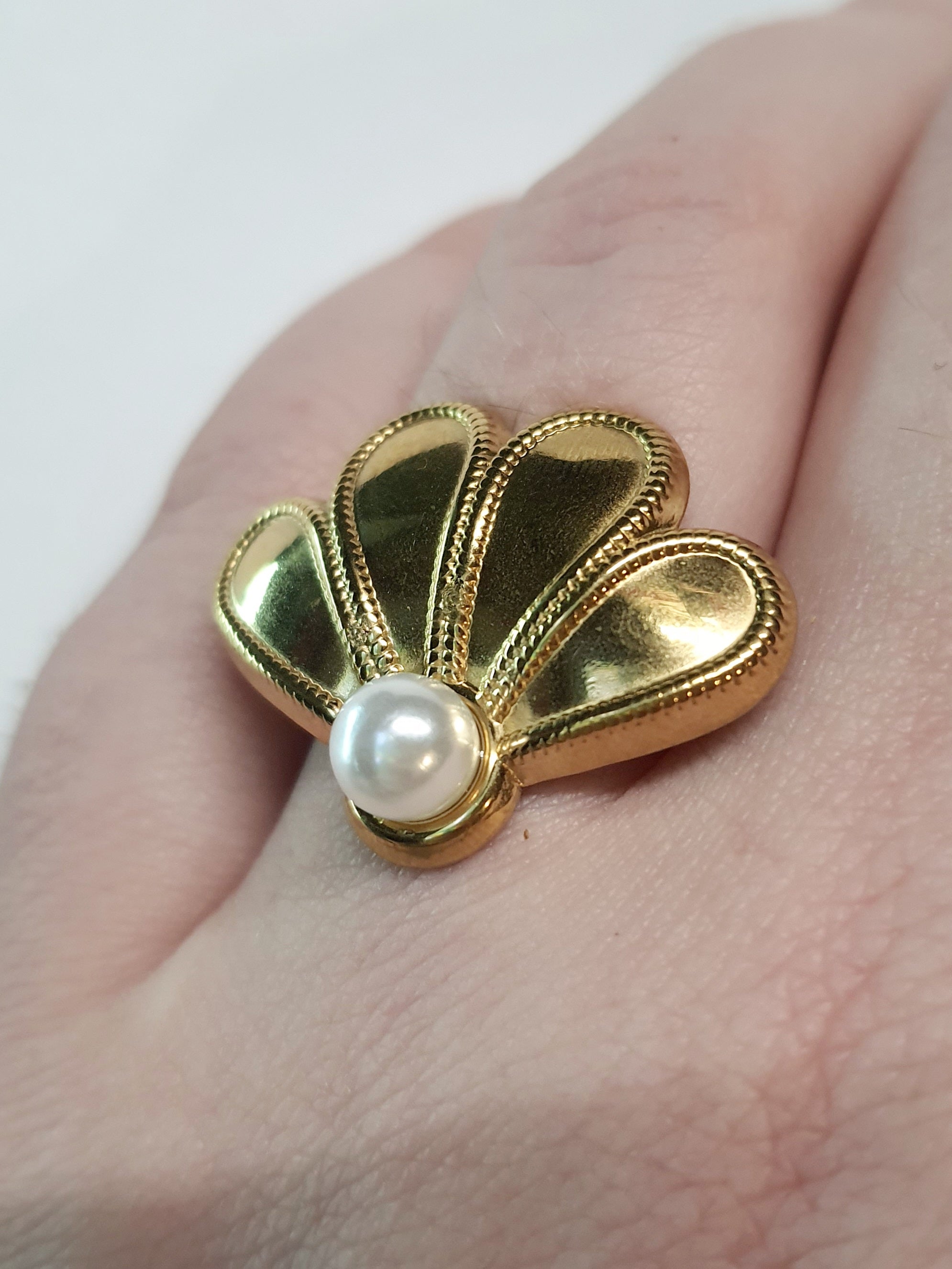 Złoty pierścionek w kształcie wachlarza z białą perłą, elegancki i nowoczesny. Rozmiar 17 mm, lekko regulowany. Stal nierdzewna, stal chirurgiczna, wodoodporne, hipoalergiczne, jakość premium. Rouge Bizu.
