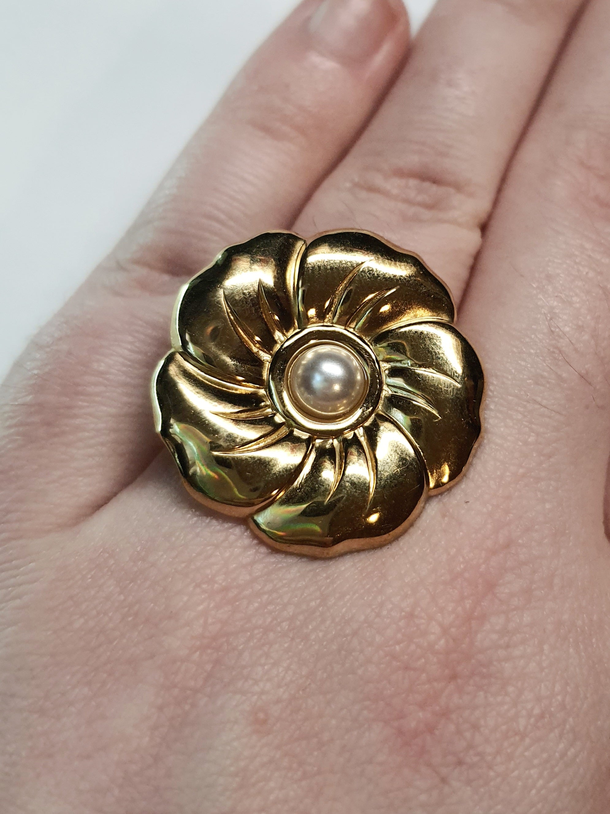 Złoty pierścionek w kształcie kwiatu z białą perłą, kobiecy i elegancki. Rozmiar 17 mm, regulowany. Stal nierdzewna, stal chirurgiczna, wodoodporne, hipoalergiczne, jakość premium. Rouge Bizu.