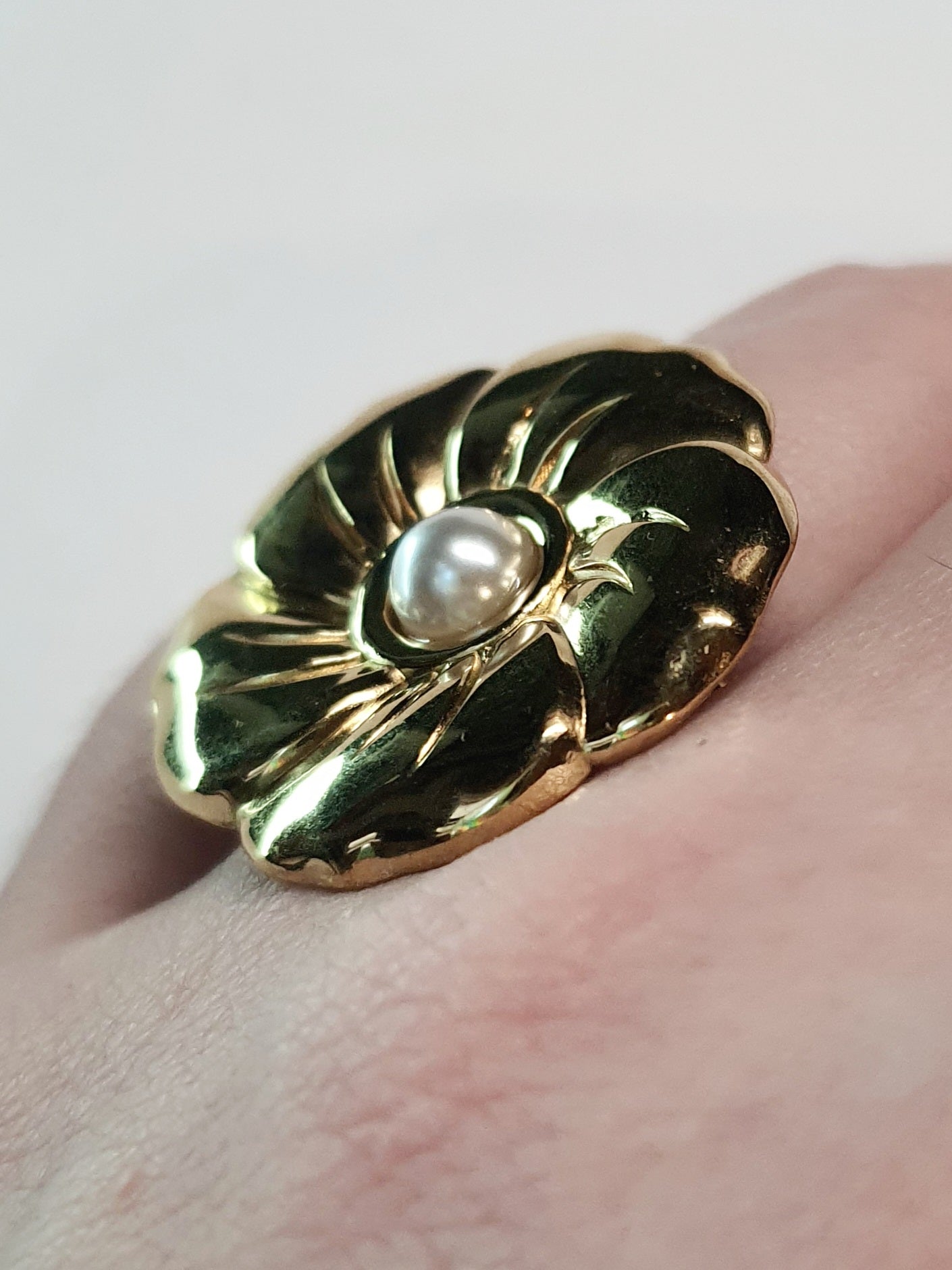 Złoty pierścionek w kształcie kwiatu z białą perłą, kobiecy i elegancki. Rozmiar 17 mm, regulowany. Stal nierdzewna, stal chirurgiczna, wodoodporne, hipoalergiczne, jakość premium. Rouge Bizu.