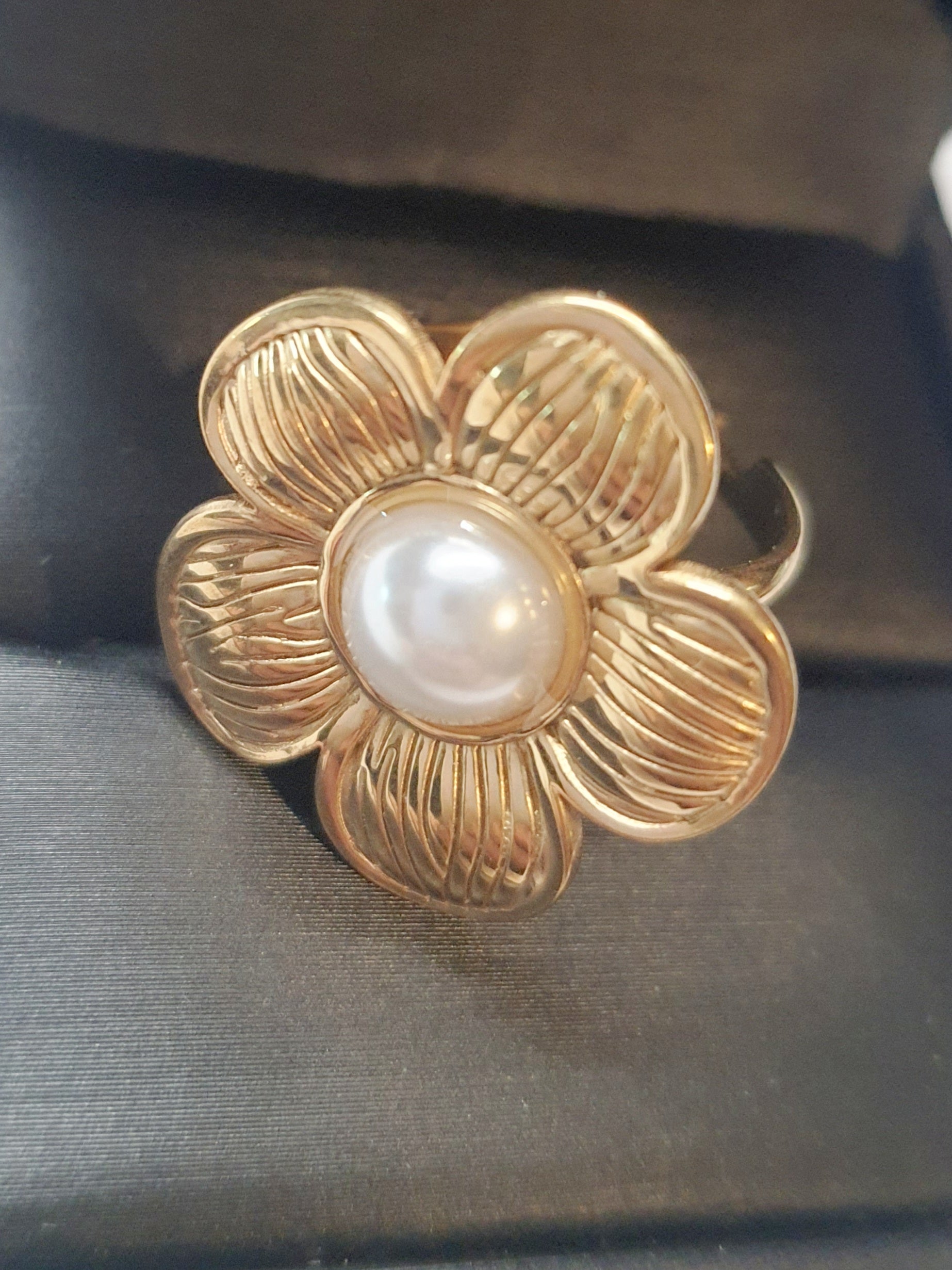 Złoty pierścionek w kształcie kwiatu z białą perłą w centrum, elegancki i kobiecy. Rozmiar 17 mm, regulowany. Stal nierdzewna, stal chirurgiczna, wodoodporne, hipoalergiczne, jakość premium. Rouge Bizu.