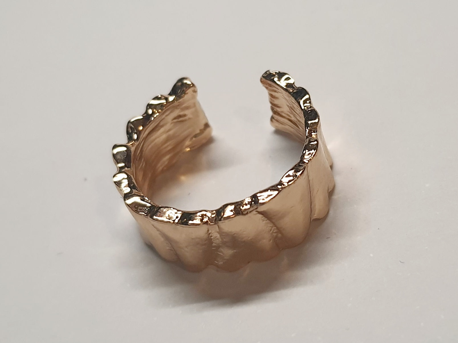 Złoty pierścionek ze stali nierdzewnej o szerokiej, falowanej strukturze w stylu minimalistycznym. Regulowany model, rozmiar 16 mm. stal chirurgiczna, stal nierdzewna, wodoodporne, hipoalergiczne, jakość premium, RougeBizu.