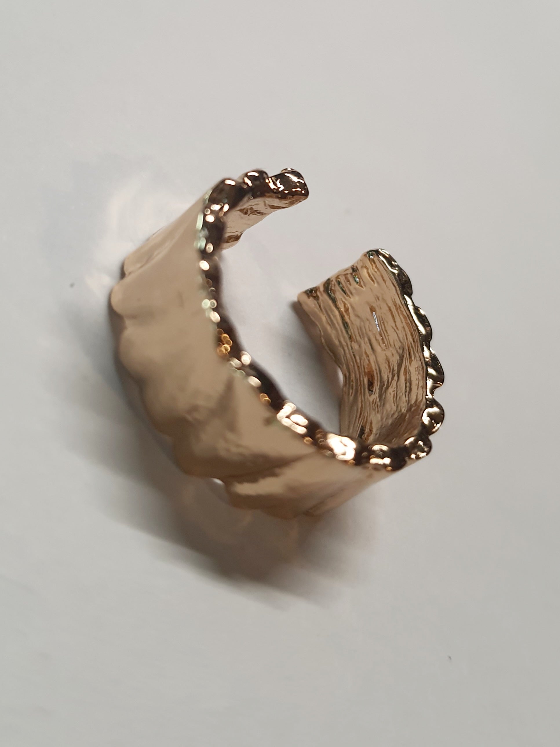 Złoty pierścionek ze stali nierdzewnej o szerokiej, falowanej strukturze w stylu minimalistycznym. Regulowany model, rozmiar 16 mm. stal chirurgiczna, stal nierdzewna, wodoodporne, hipoalergiczne, jakość premium, RougeBizu.
