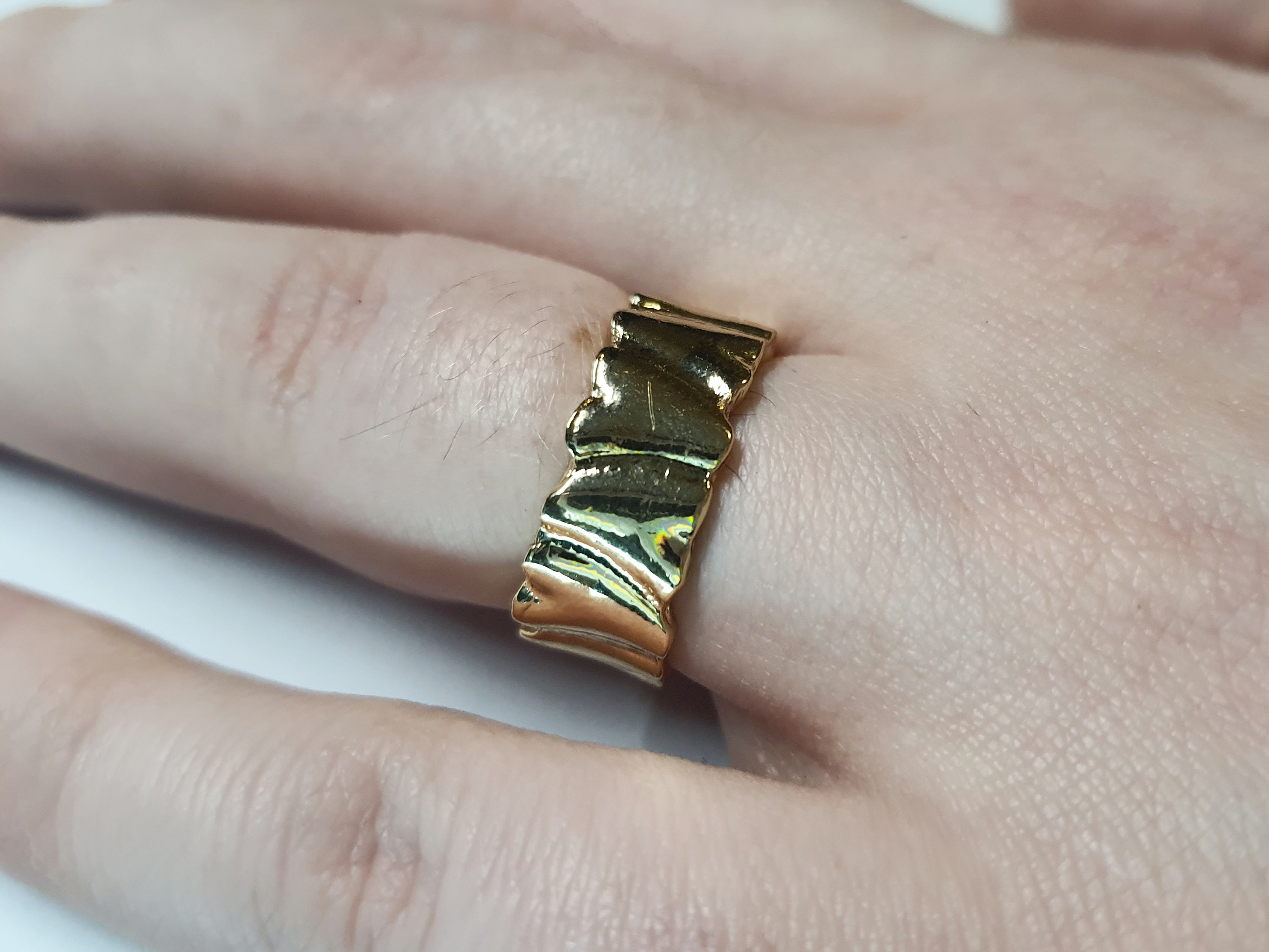 Złoty pierścionek ze stali nierdzewnej o szerokiej, falowanej strukturze w stylu minimalistycznym. Regulowany model, rozmiar 16 mm. stal chirurgiczna, stal nierdzewna, wodoodporne, hipoalergiczne, jakość premium, RougeBizu.