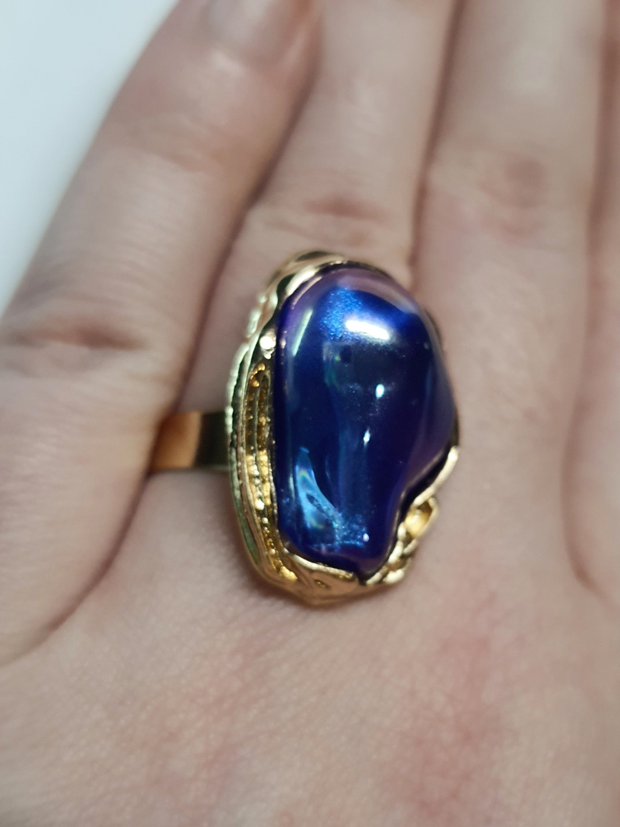 Pierścionek Aurora ze stali chirurgicznej, stal nierdzewna, złota oprawa z opalizującym kamieniem w kolorach fioletu i błękitu, styl glamour, rozmiar 18 mm, wodoodporny, hipoalergiczny, jakość premium, Rouge Bizu.