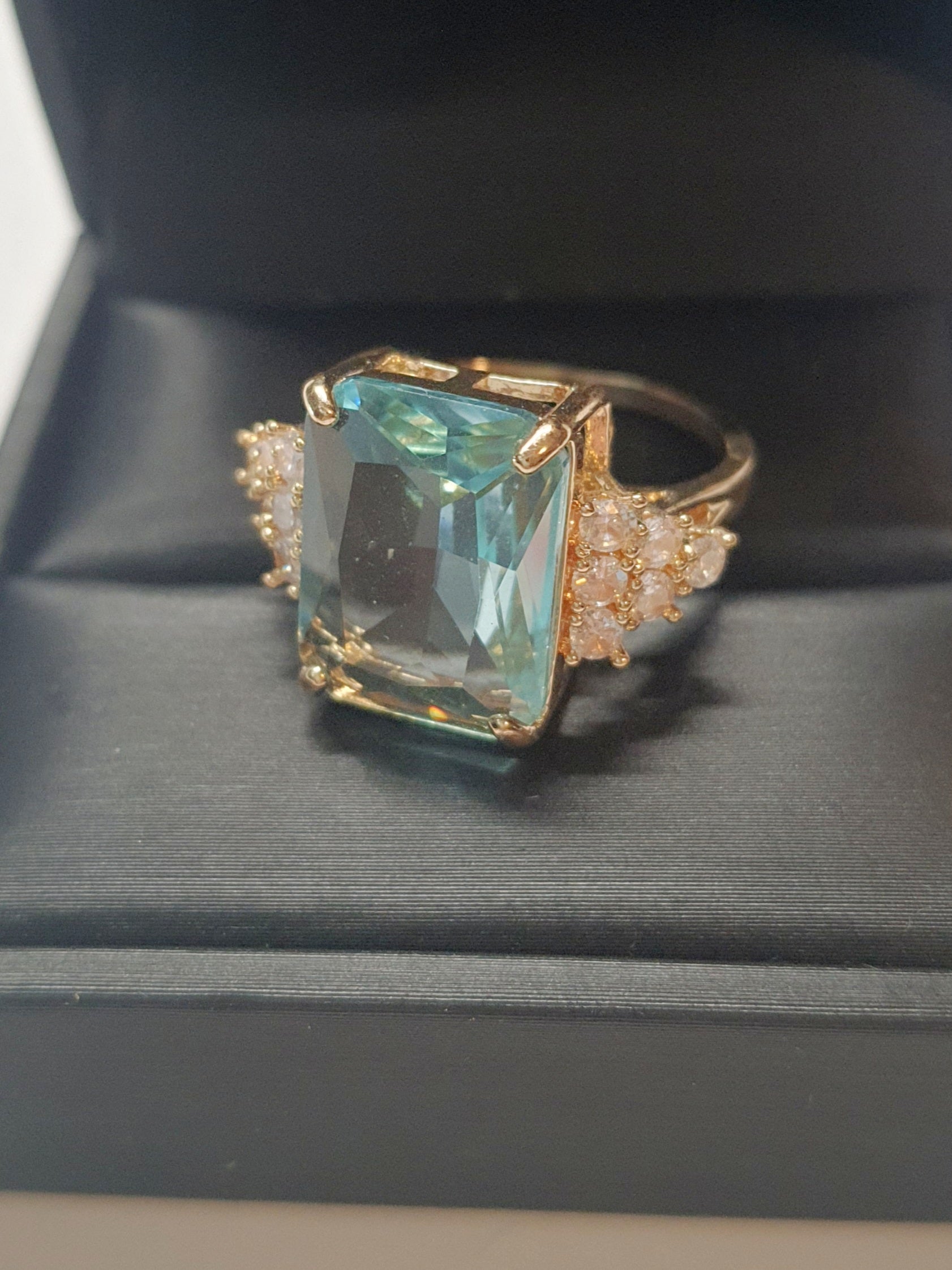 Złoty pierścionek ze stali nierdzewnej z prostokątnym błękitnym kamieniem i cyrkoniami po bokach w stylu glamour klasycznym. Rozmiar 20 mm. stal chirurgiczna, stal nierdzewna, wodoodporne, hipoalergiczne, jakość premium, RougeBizu.
