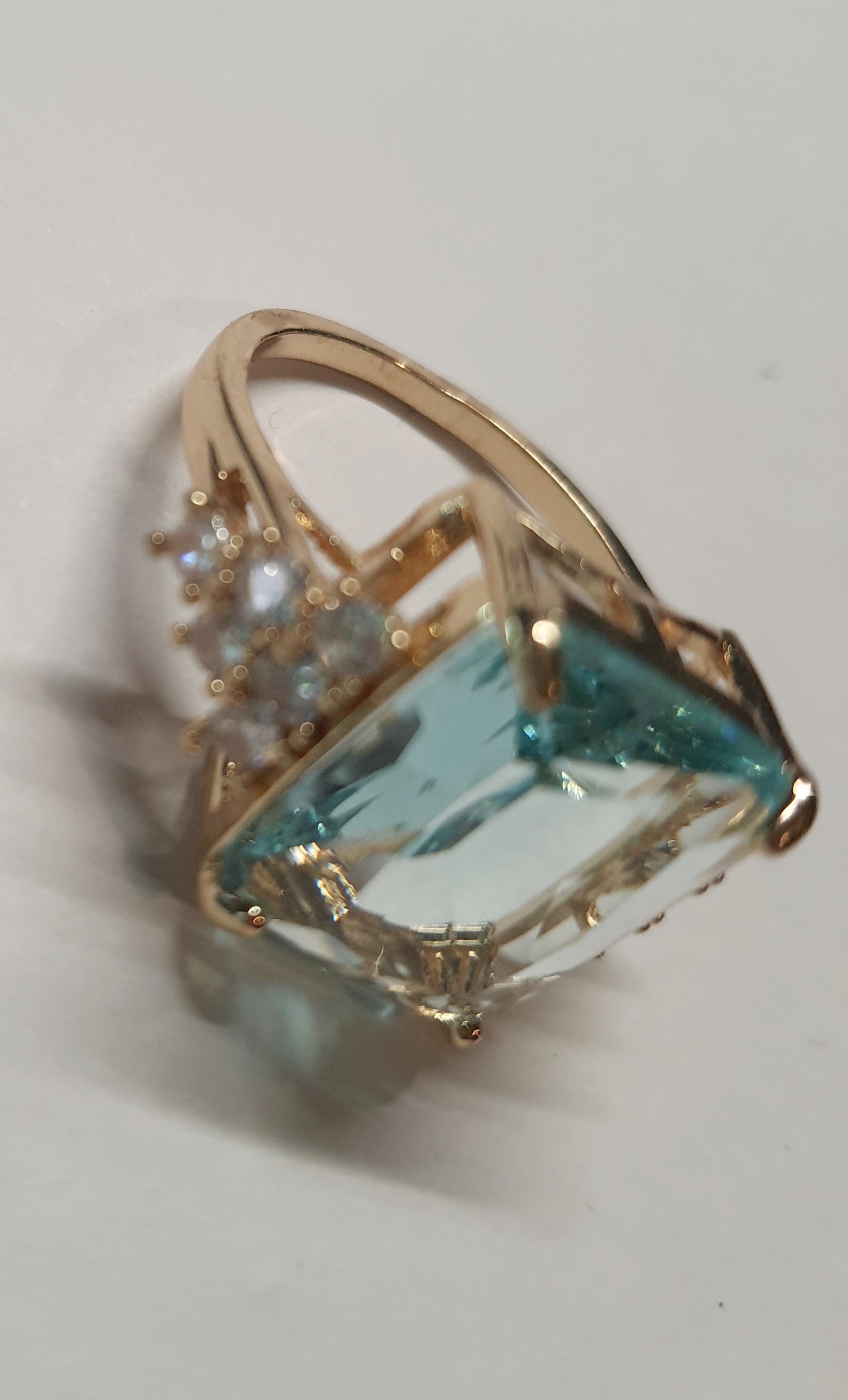 Złoty pierścionek ze stali nierdzewnej z prostokątnym błękitnym kamieniem i cyrkoniami po bokach w stylu glamour klasycznym. Rozmiar 20 mm. stal chirurgiczna, stal nierdzewna, wodoodporne, hipoalergiczne, jakość premium, RougeBizu.