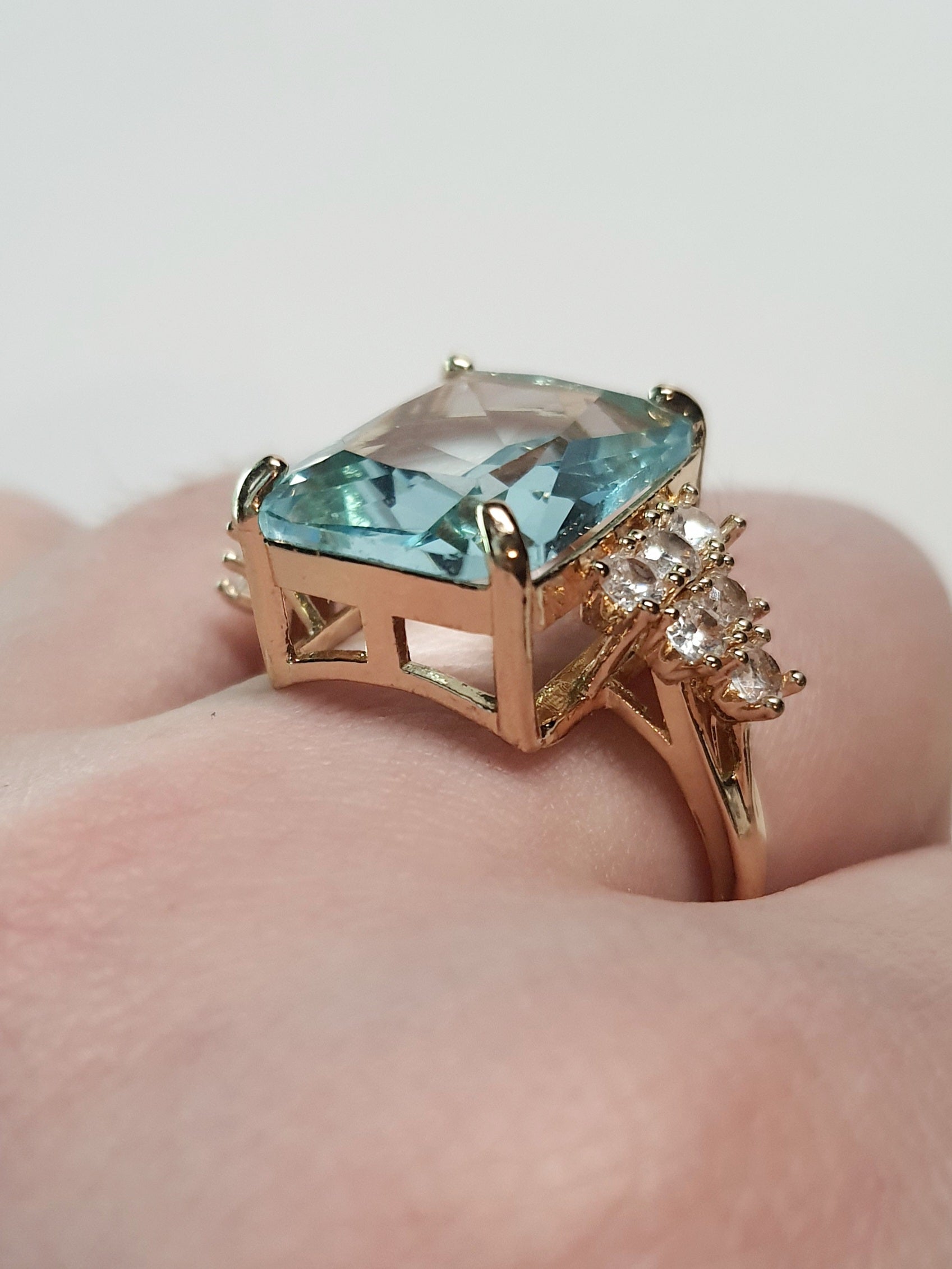 Złoty pierścionek ze stali nierdzewnej z prostokątnym błękitnym kamieniem i cyrkoniami po bokach w stylu glamour klasycznym. Rozmiar 20 mm. stal chirurgiczna, stal nierdzewna, wodoodporne, hipoalergiczne, jakość premium, RougeBizu.