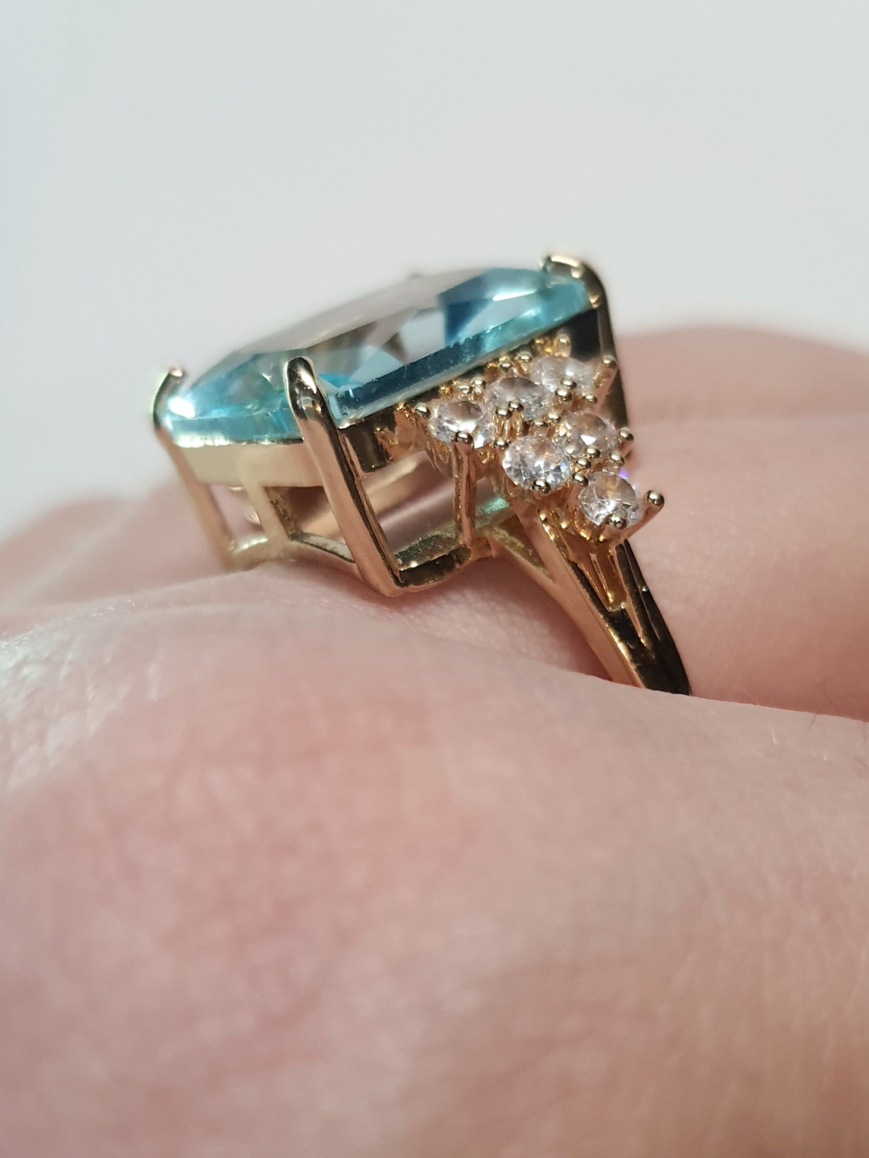 Złoty pierścionek ze stali nierdzewnej z prostokątnym błękitnym kamieniem i cyrkoniami po bokach w stylu glamour klasycznym. Rozmiar 20 mm. stal chirurgiczna, stal nierdzewna, wodoodporne, hipoalergiczne, jakość premium, RougeBizu.