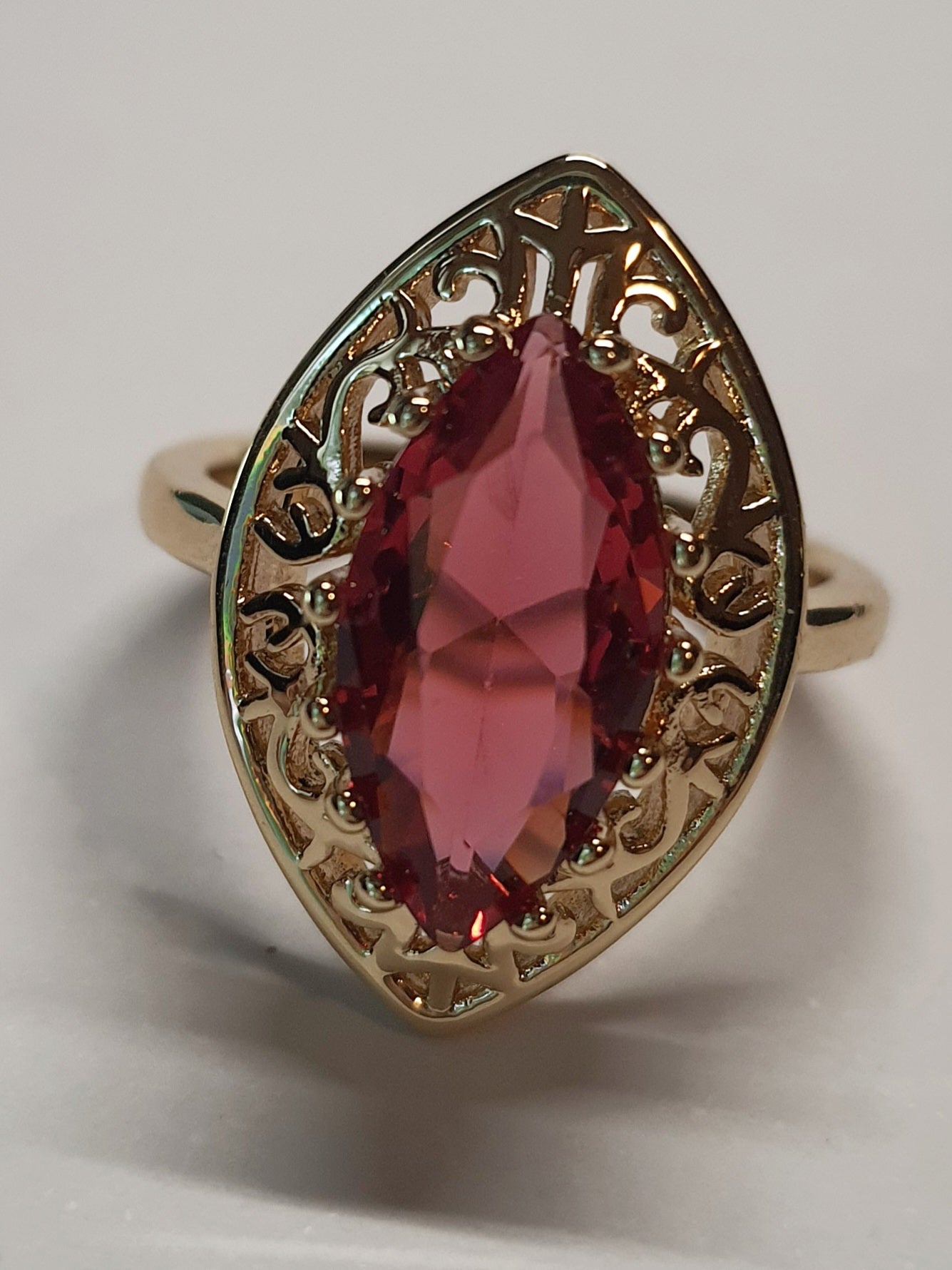 Złoty pierścionek ze stali nierdzewnej z czerwonym kamieniem w kształcie łzy w ażurowej oprawie w stylu glamour vintage. Rozmiar 19 mm. stal chirurgiczna, stal nierdzewna, wodoodporne, hipoalergiczne, jakość premium, RougeBizu.