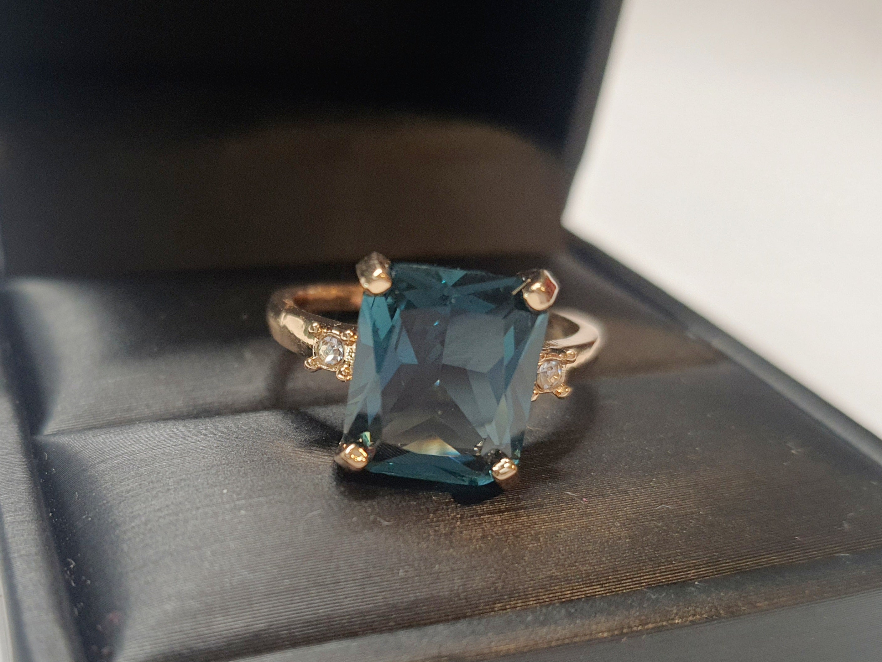 Złoty pierścionek ze stali nierdzewnej z prostokątnym szafirowym kamieniem i drobnymi cyrkoniami po bokach w stylu klasycznym glamour. Rozmiar 19 mm. stal chirurgiczna, stal nierdzewna, wodoodporne, hipoalergiczne, jakość premium, RougeBizu.