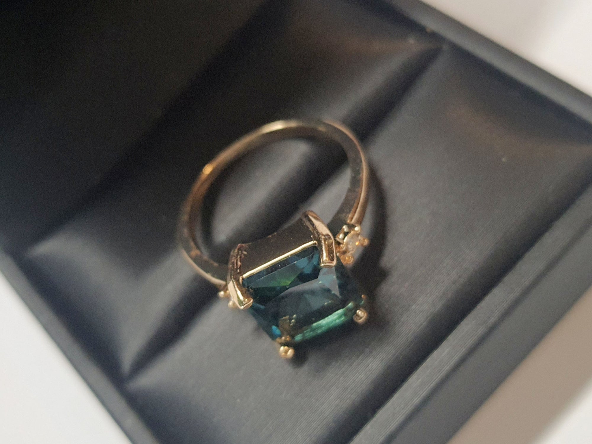 Złoty pierścionek ze stali nierdzewnej z prostokątnym szafirowym kamieniem i drobnymi cyrkoniami po bokach w stylu klasycznym glamour. Rozmiar 19 mm. stal chirurgiczna, stal nierdzewna, wodoodporne, hipoalergiczne, jakość premium, RougeBizu.