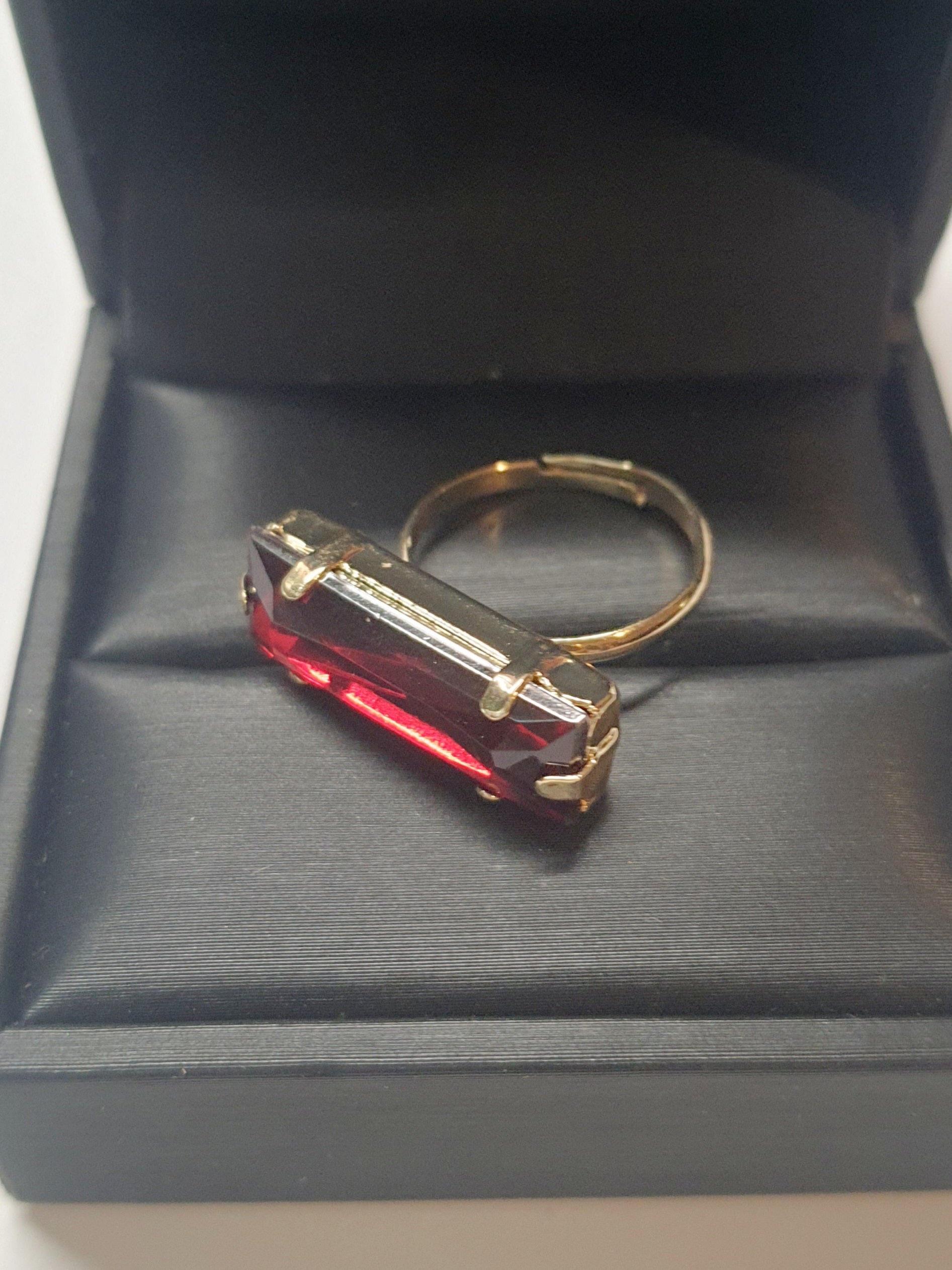 Złoty pierścionek z długim rubinowym kamieniem w stylu glamour vintage, elegancki i efektowny. Rozmiar 17 mm, lekko regulowany. Stal nierdzewna, stal chirurgiczna, wodoodporne, hipoalergiczne, jakość premium. Rouge Bizu.