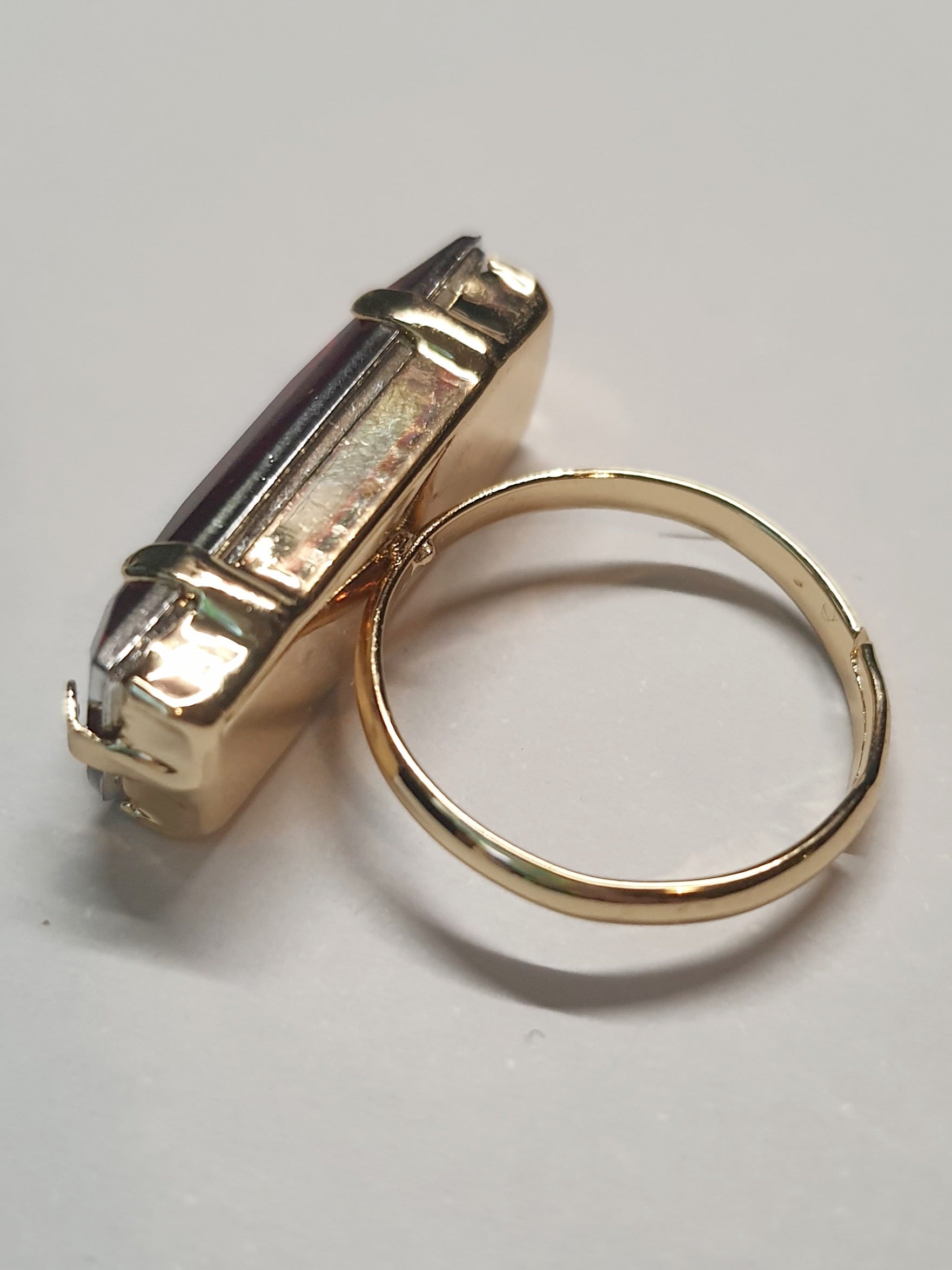 Złoty pierścionek z długim rubinowym kamieniem w stylu glamour vintage, elegancki i efektowny. Rozmiar 17 mm, lekko regulowany. Stal nierdzewna, stal chirurgiczna, wodoodporne, hipoalergiczne, jakość premium. Rouge Bizu.