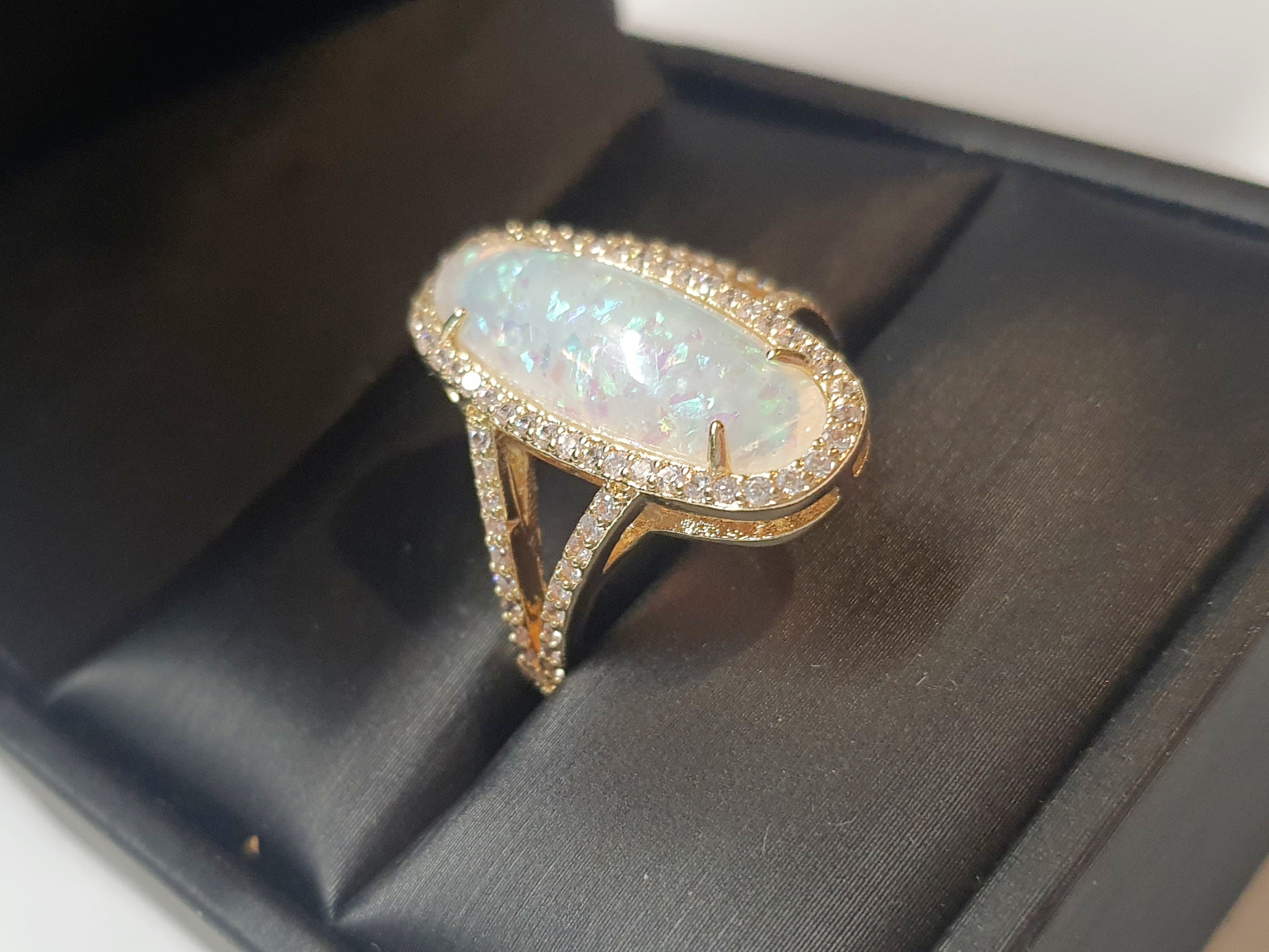 Złoty pierścionek ze stali nierdzewnej z podłużnym opalizującym kamieniem i cyrkoniami w stylu glamour eleganckim. Rozmiar 19 mm. stal chirurgiczna, stal nierdzewna, wodoodporne, hipoalergiczne, jakość premium, RougeBizu.