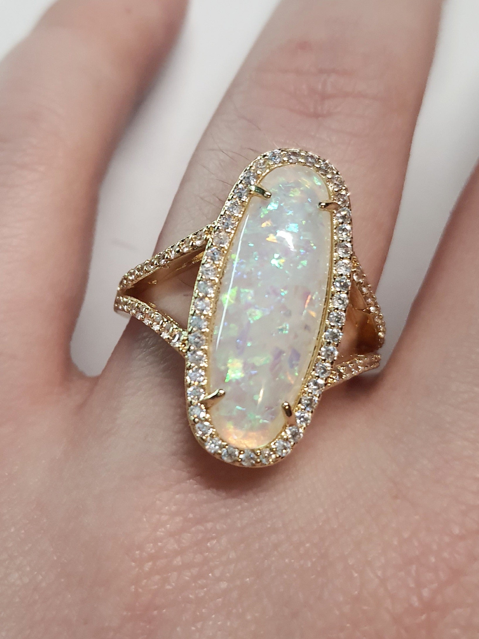 Złoty pierścionek ze stali nierdzewnej z podłużnym opalizującym kamieniem i cyrkoniami w stylu glamour eleganckim. Rozmiar 19 mm. stal chirurgiczna, stal nierdzewna, wodoodporne, hipoalergiczne, jakość premium, RougeBizu.