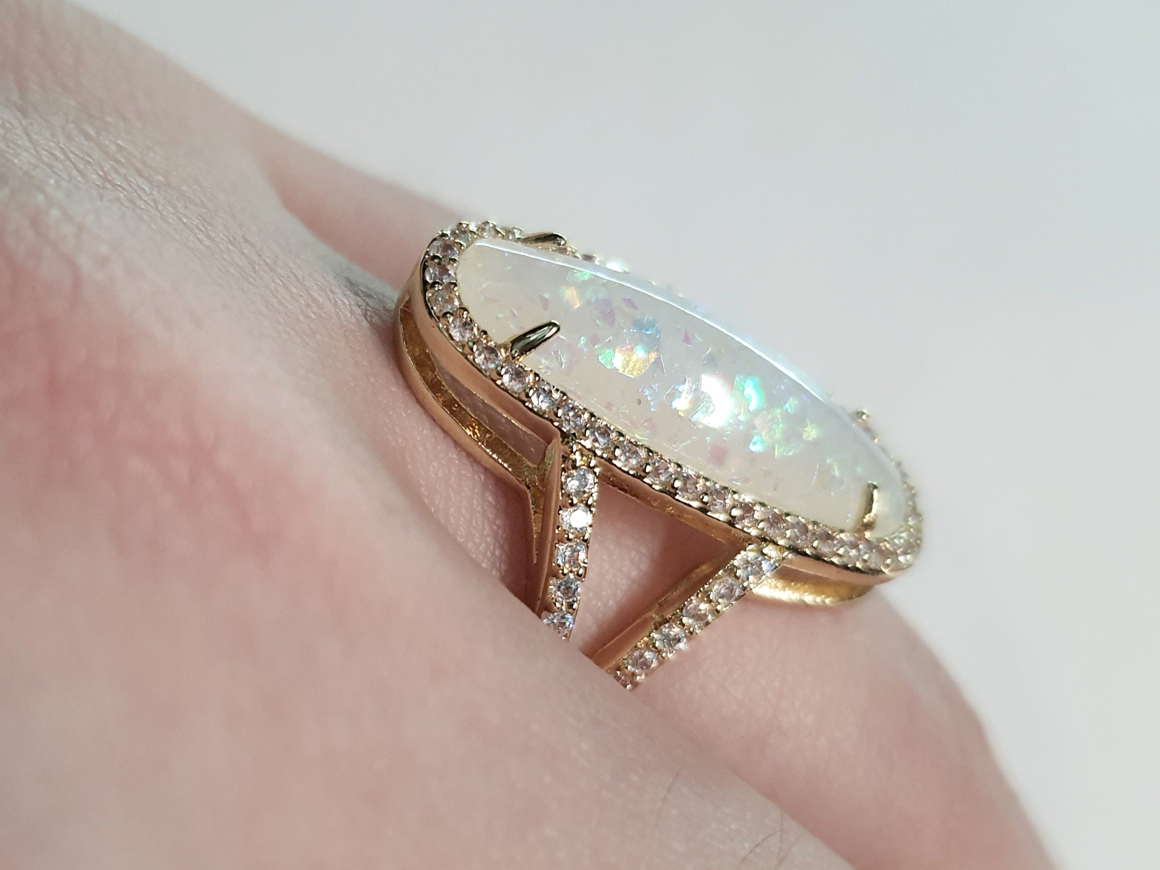 Złoty pierścionek ze stali nierdzewnej z podłużnym opalizującym kamieniem i cyrkoniami w stylu glamour eleganckim. Rozmiar 19 mm. stal chirurgiczna, stal nierdzewna, wodoodporne, hipoalergiczne, jakość premium, RougeBizu.