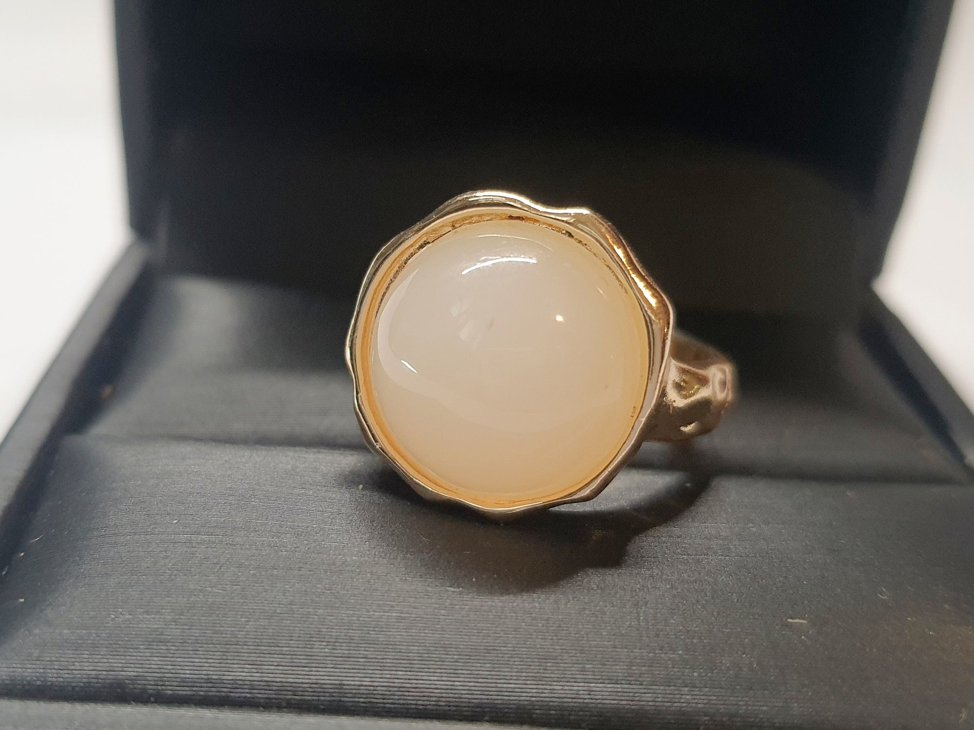 Złoty pierścionek z kremowym kamieniem w falującej oprawie, stal chirurgiczna, stal nierdzewna, polerowany, elegancki, minimalistyczny, rozmiar 15 mm, wodoodporny, hipoalergiczny, jakość premium, Rouge Bizu.