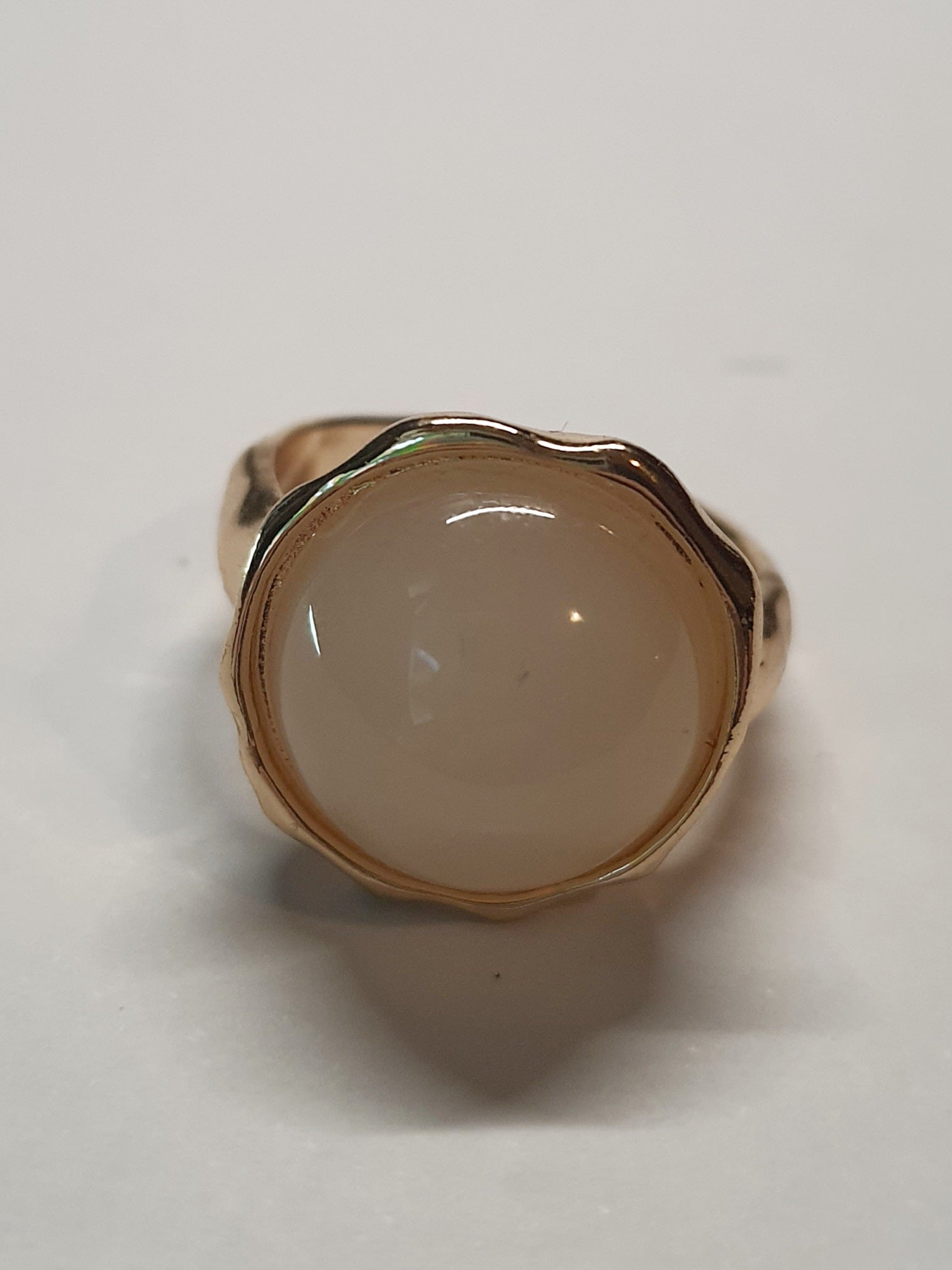Złoty pierścionek z kremowym kamieniem w falującej oprawie, stal chirurgiczna, stal nierdzewna, polerowany, elegancki, minimalistyczny, rozmiar 15 mm, wodoodporny, hipoalergiczny, jakość premium, Rouge Bizu.