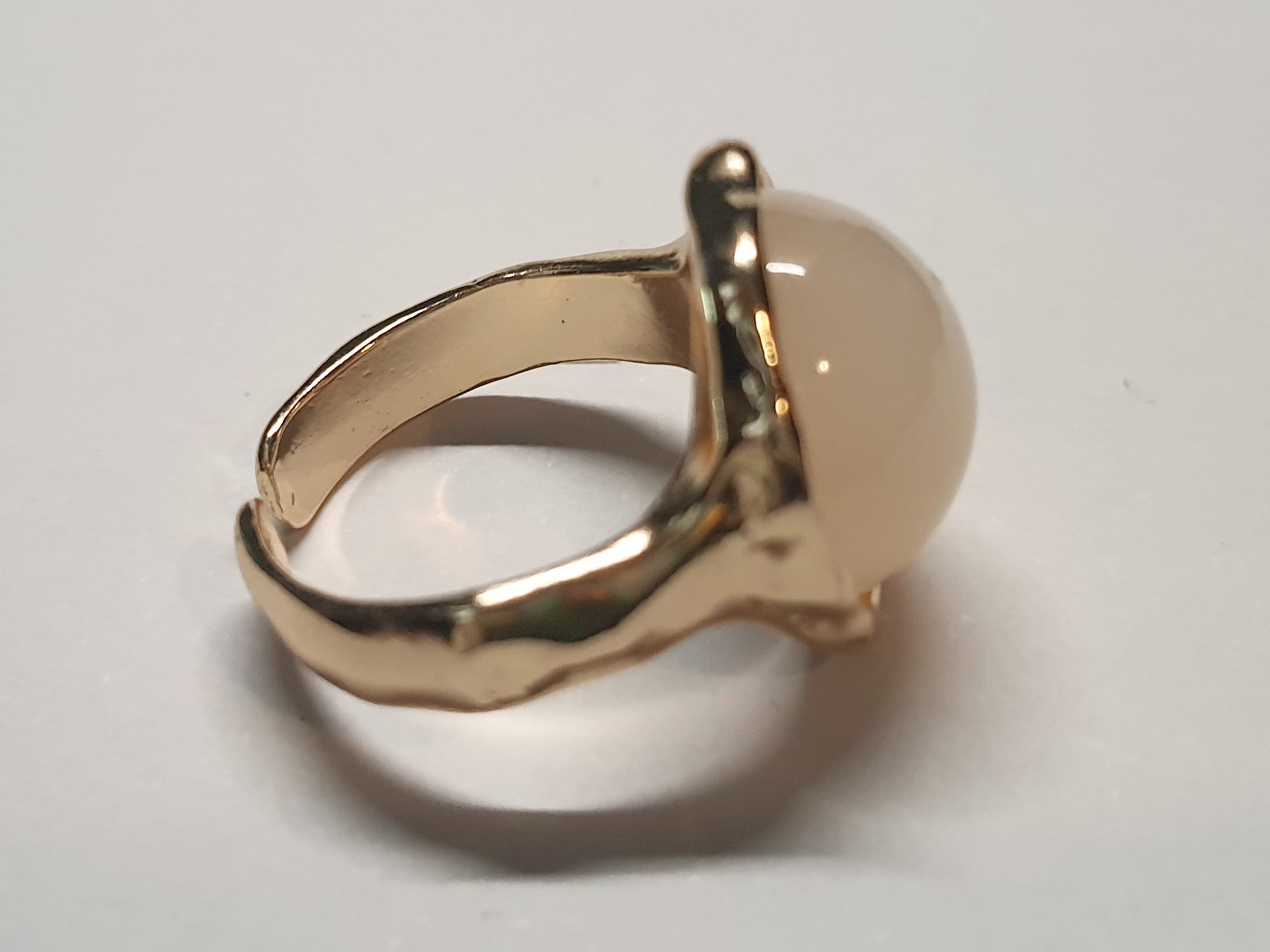 Złoty pierścionek z kremowym kamieniem w falującej oprawie, stal chirurgiczna, stal nierdzewna, polerowany, elegancki, minimalistyczny, rozmiar 15 mm, wodoodporny, hipoalergiczny, jakość premium, Rouge Bizu.