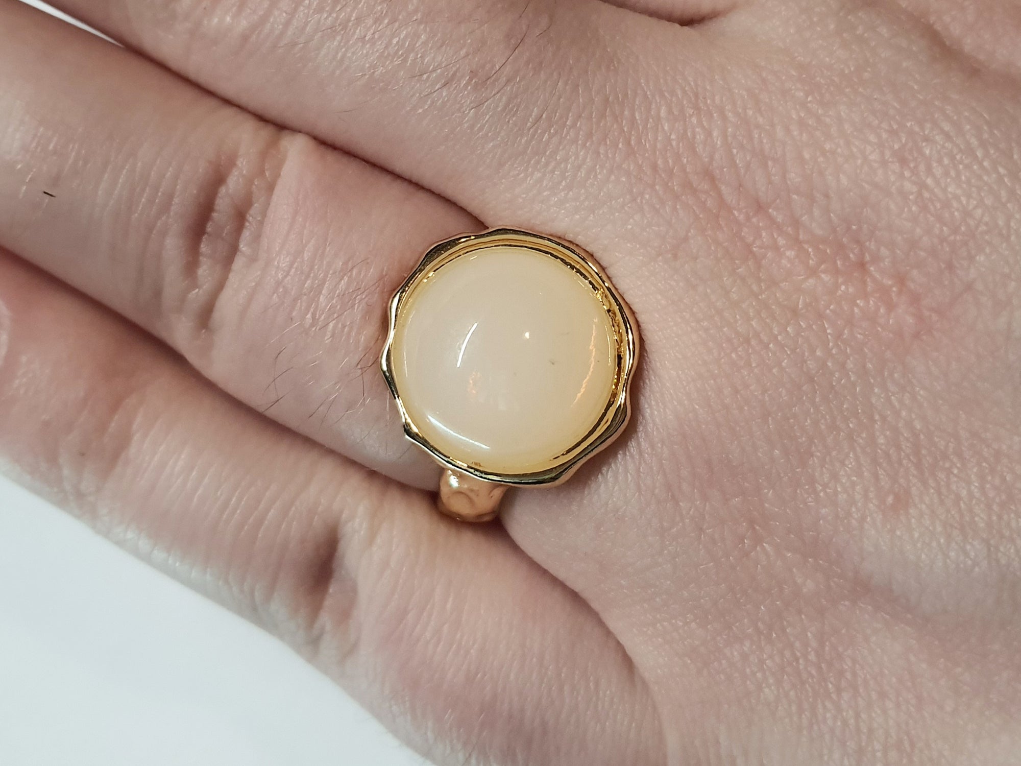 Złoty pierścionek z kremowym kamieniem w falującej oprawie, stal chirurgiczna, stal nierdzewna, polerowany, elegancki, minimalistyczny, rozmiar 15 mm, wodoodporny, hipoalergiczny, jakość premium, Rouge Bizu.