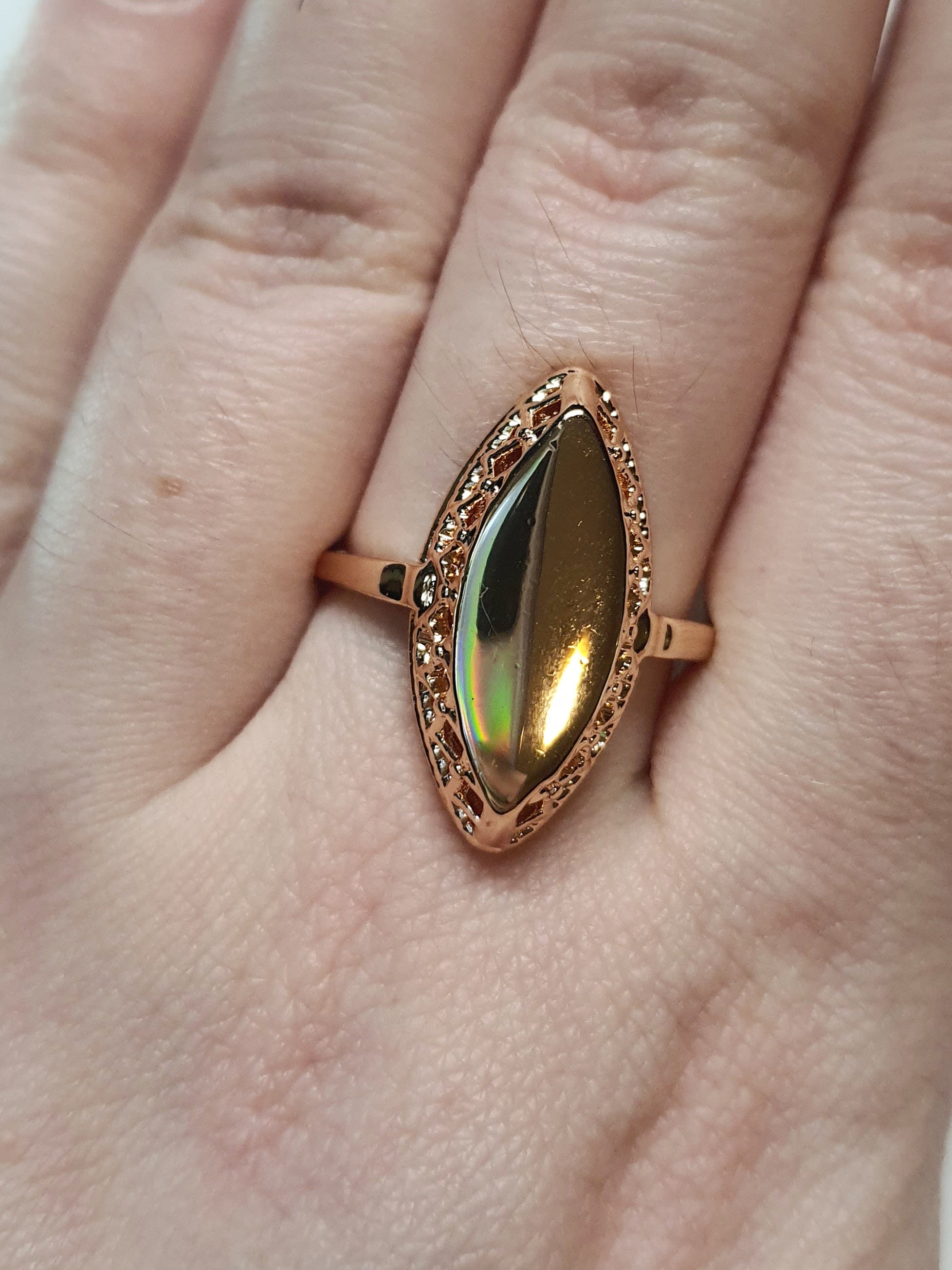Złoty pierścionek ze stali nierdzewnej z opalizującym lustrzanym kamieniem w kształcie łezki, w stylu glamour i eleganckim. Rozmiar 19 mm. stal chirurgiczna, stal nierdzewna, wodoodporne, hipoalergiczne, jakość premium, RougeBizu.