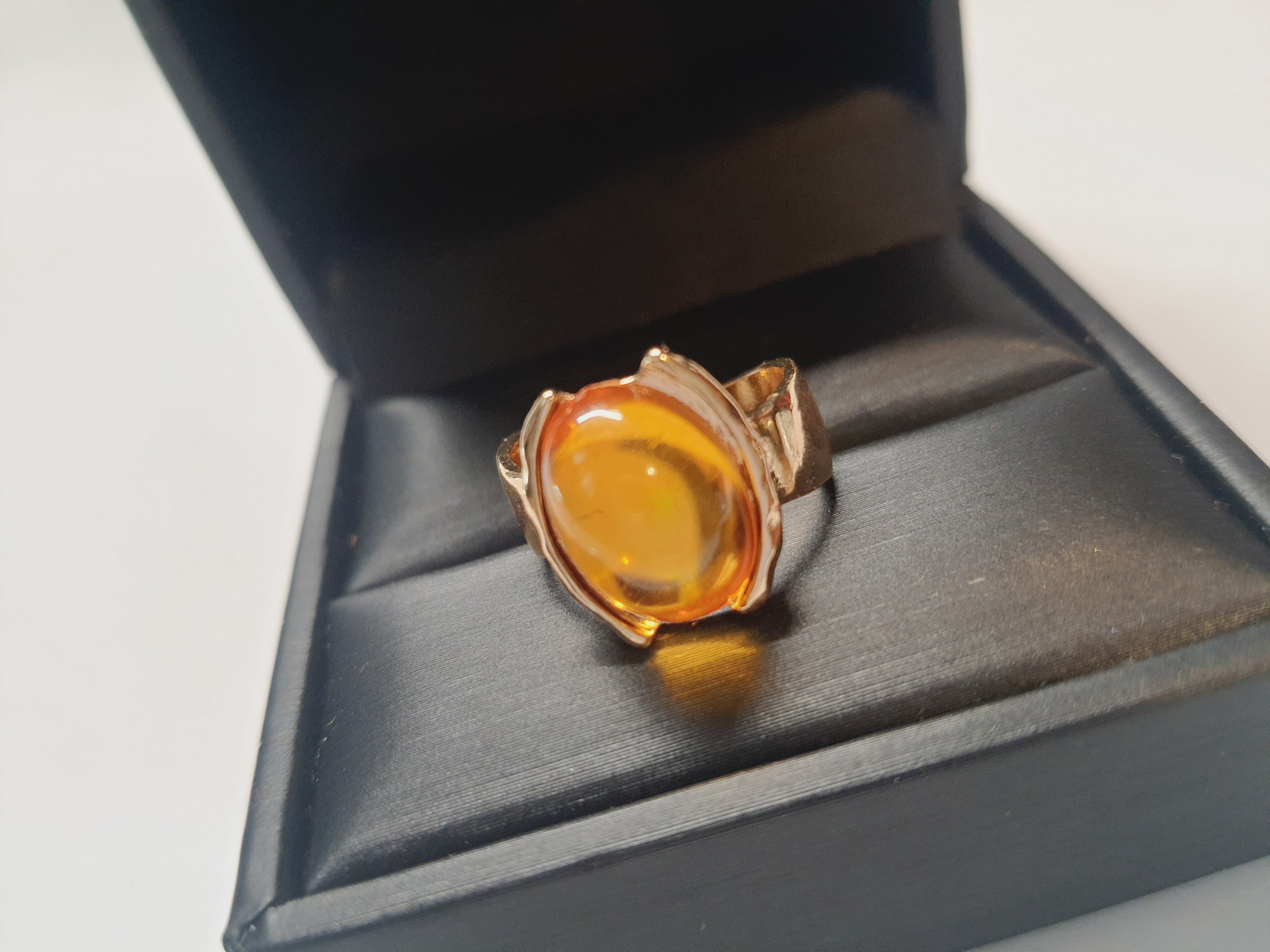 Złoty pierścionek ze stali nierdzewnej z owalnym bursztynowym kamieniem w artystycznej oprawie o nieregularnej formie. Rozmiar 16 mm. stal chirurgiczna, stal nierdzewna, wodoodporne, hipoalergiczne, jakość premium, RougeBizu.