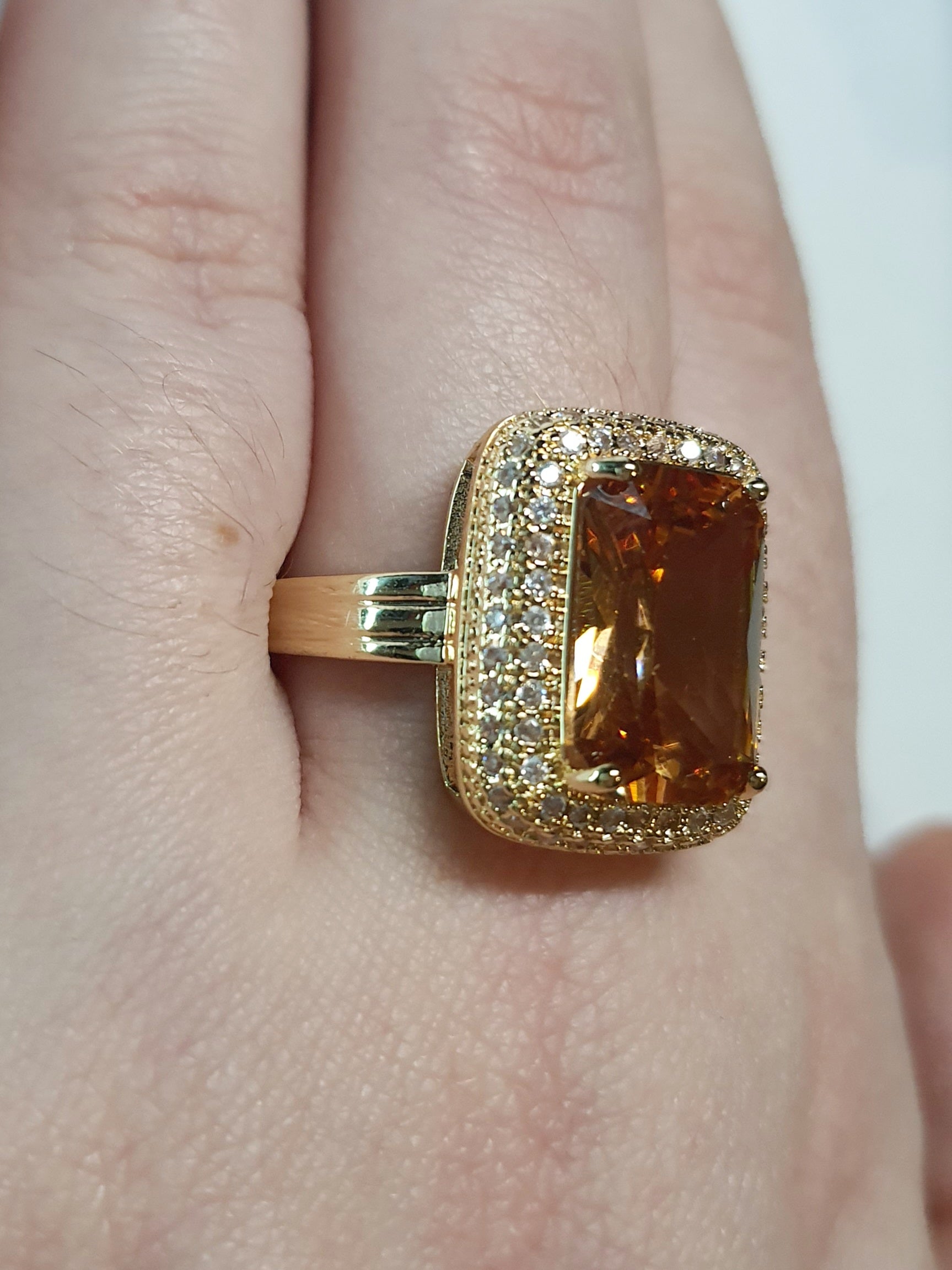 Pierścionek ze złotej stali nierdzewnej z prostokątnym miodowym kamieniem w stylu glamour vintage, otoczony cyrkoniami, elegancki i kobiecy. Rozmiar 19 mm. stal chirurgiczna, stal nierdzewna, wodoodporne, hipoalergiczne, jakość premium, RougeBizu.