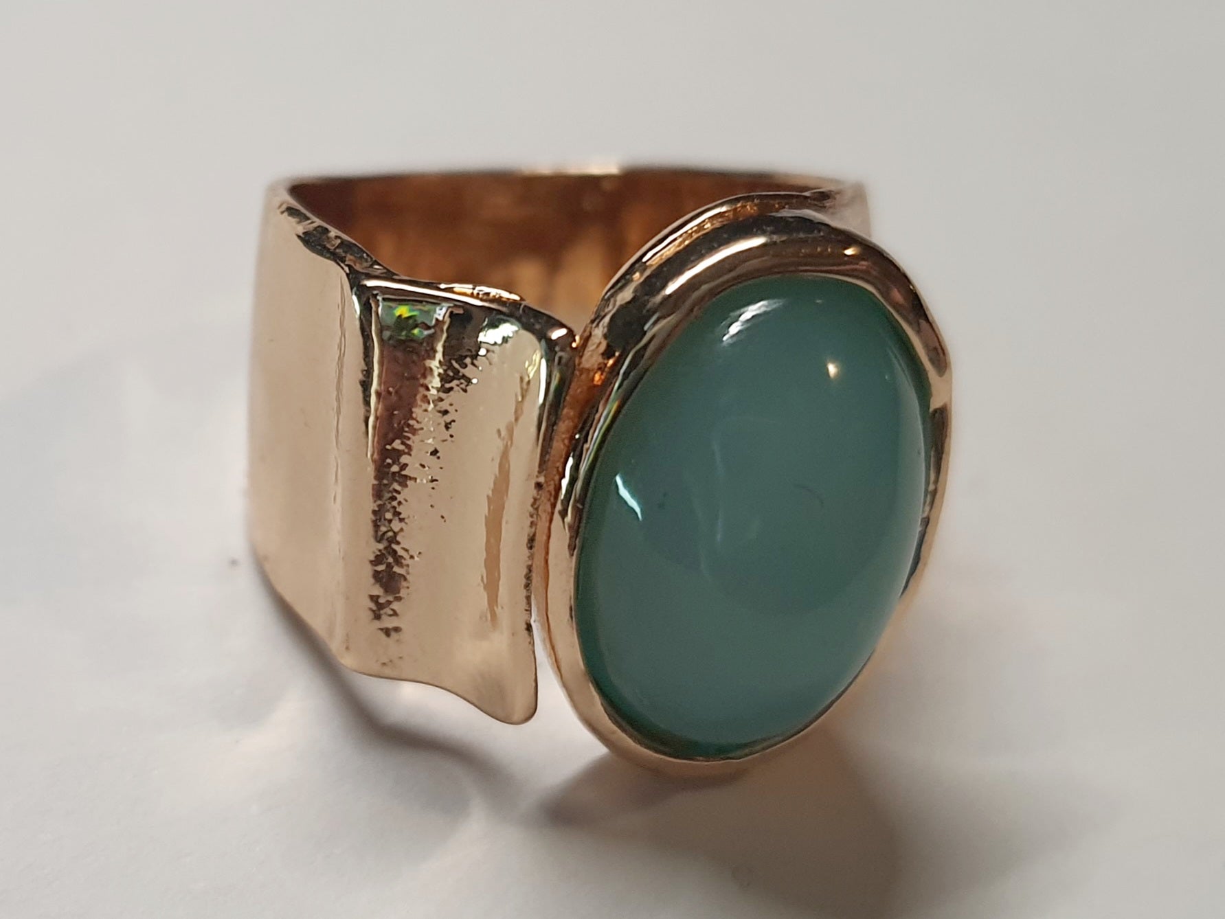Złoty pierścionek ze stali nierdzewnej z owalnym kamieniem w kolorze morskiej zieleni, o nieregularnej formie w stylu artystycznym i retro. Rozmiar 16 mm. stal chirurgiczna, stal nierdzewna, wodoodporne, hipoalergiczne, jakość premium, RougeBizu.