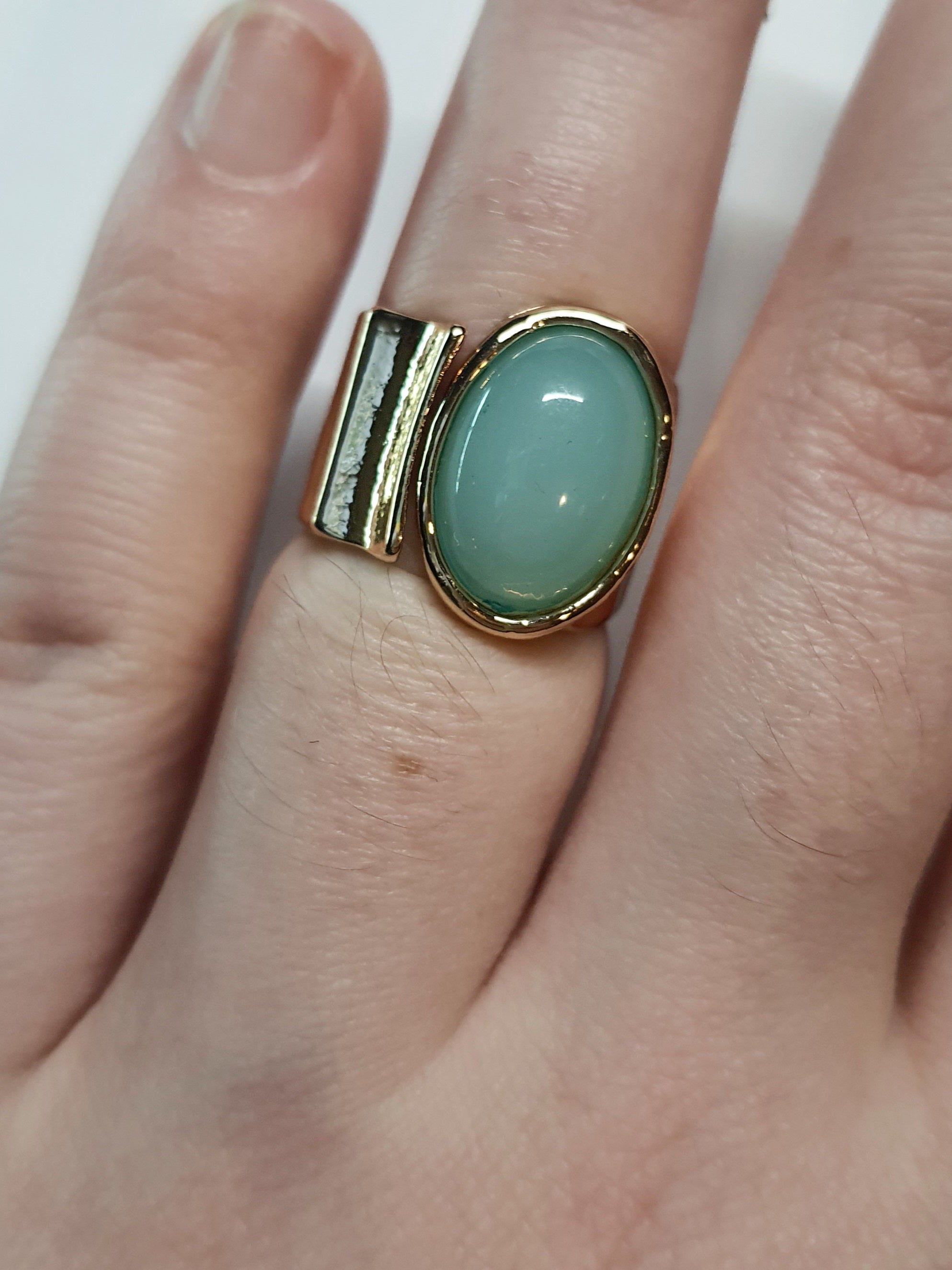 Złoty pierścionek ze stali nierdzewnej z owalnym kamieniem w kolorze morskiej zieleni, o nieregularnej formie w stylu artystycznym i retro. Rozmiar 16 mm. stal chirurgiczna, stal nierdzewna, wodoodporne, hipoalergiczne, jakość premium, RougeBizu.