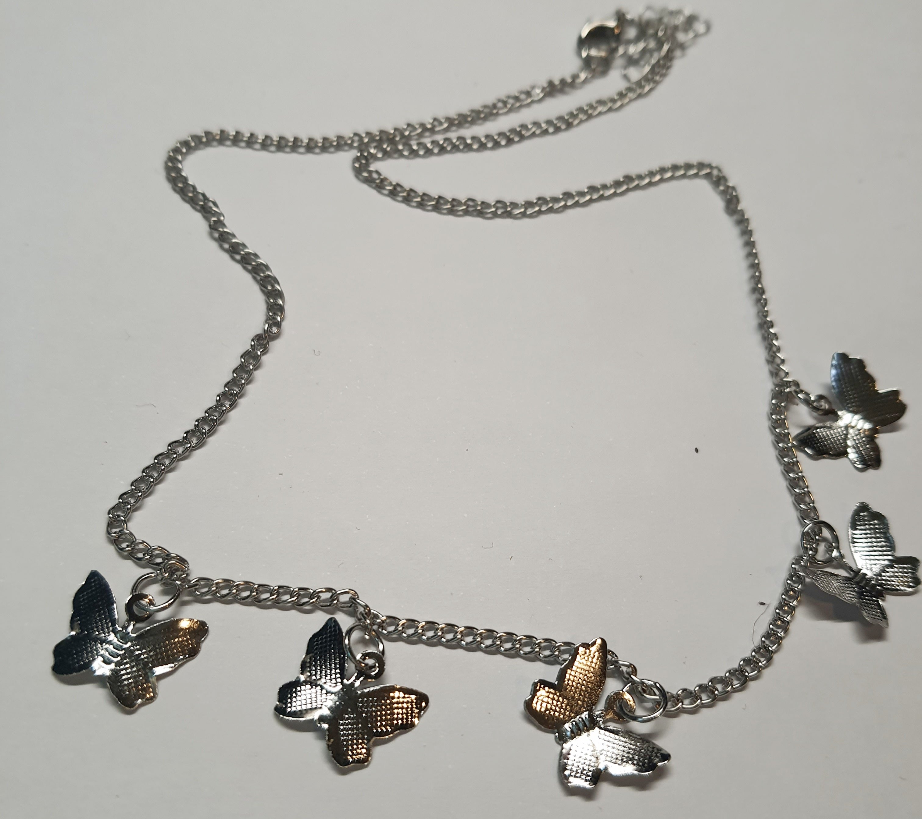 Srebrny łańcuszek celebrytka z zawieszkami w kształcie motylków, stal chirurgiczna, stal nierdzewna, wodoodporne, hipoalergiczne, jakość premium, długość 40–46 cm, RougeBizu.