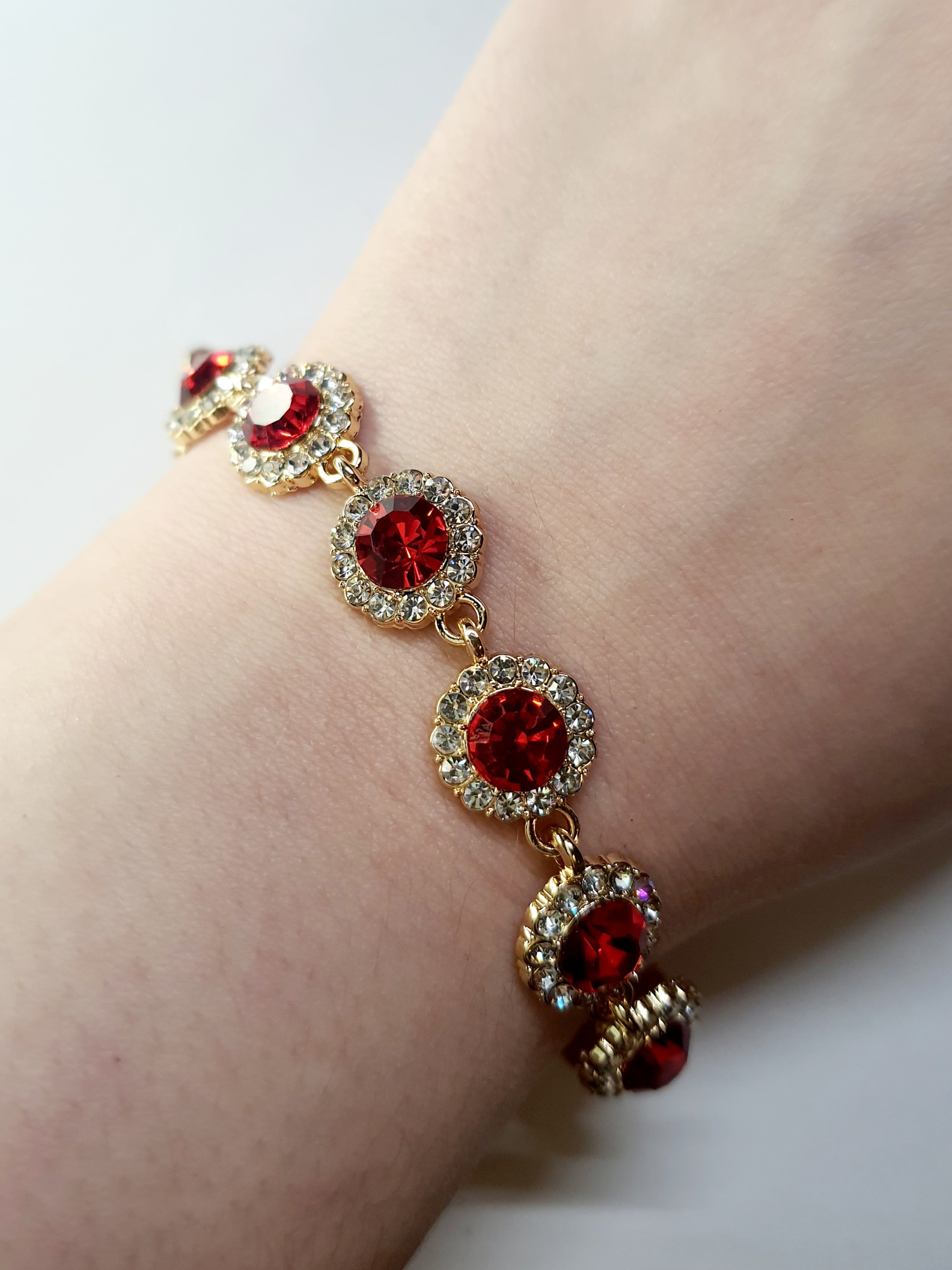 Bransoletka z czerwonymi kamieniami w złotej oprawie, długość regulowana 15–20 cm, styl glamour i elegancki. Stal nierdzewna, stal chirurgiczna, wodoodporne, hipoalergiczne, jakość premium, Rouge Bizu.